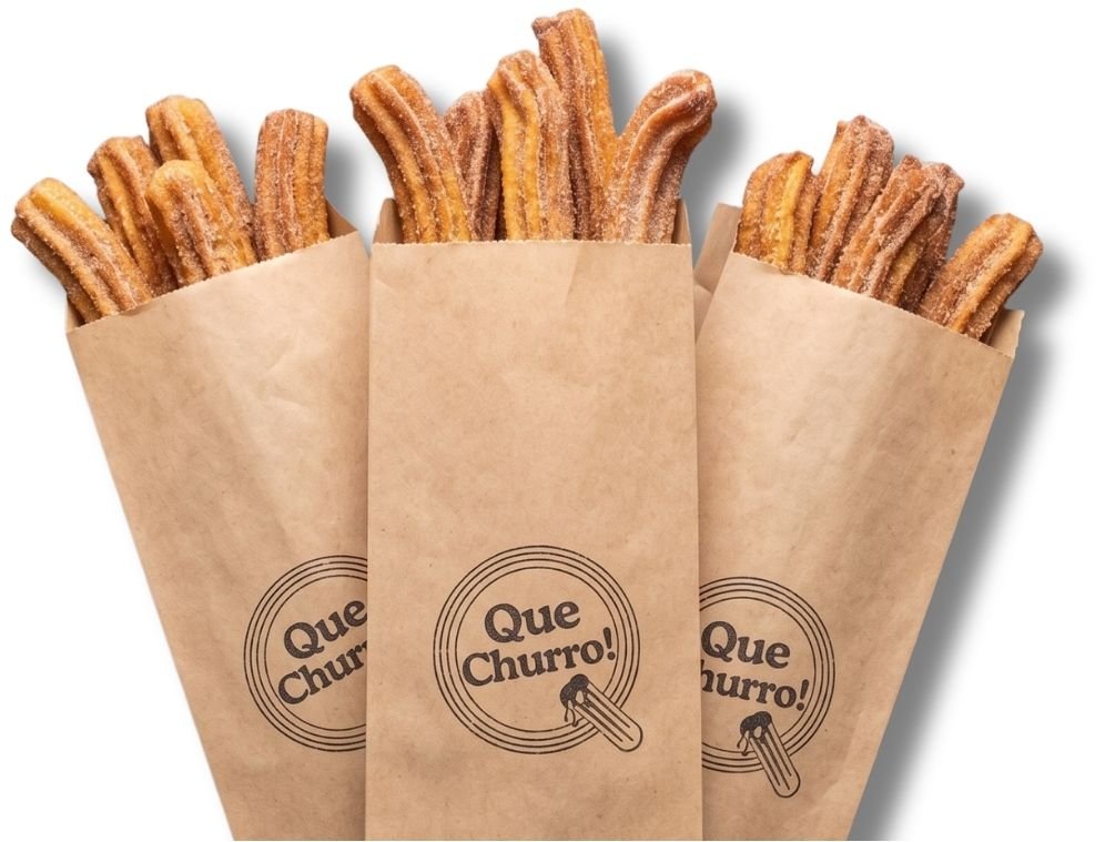 Three paper bags of churros with a logo that says "Que Churro!" on each