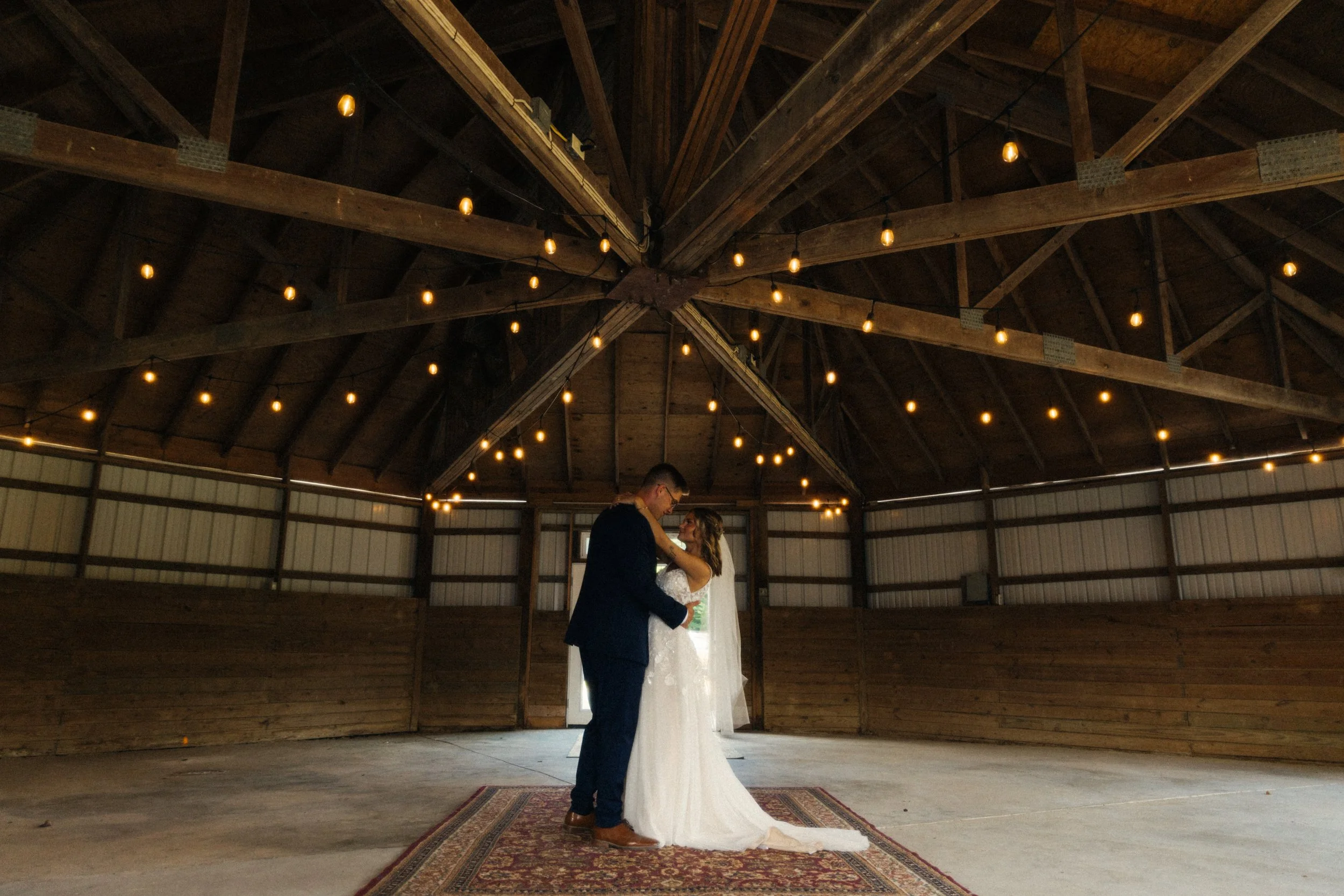 St. Louis Documentary-style wedding photography on 35mm film, 120 film, and digital by Trevor Lovatto. A bride and groom dancing in a rustic, wood-paneled barn with string lights hanging from the ceiling.