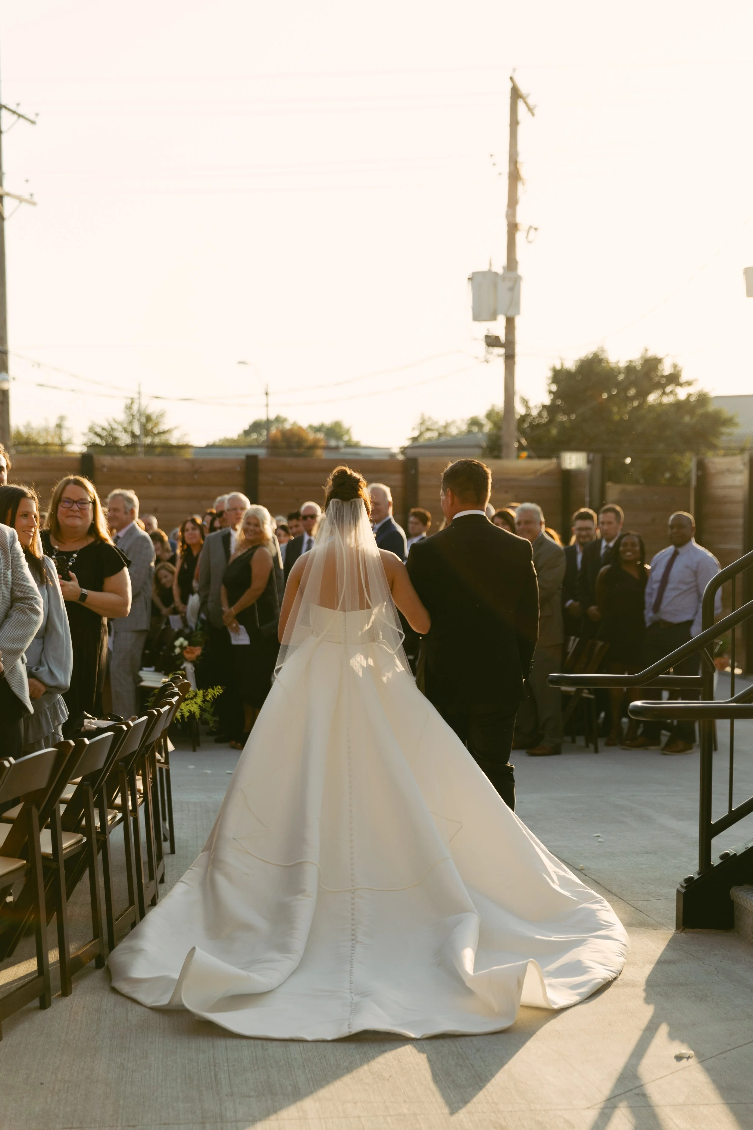 Bride and groom walking down the aisle at their wedding ceremony outdoors with guests seated on either side. St. Louis Documentary-style wedding photography on 35mm film, 120 film, and digital by Trevor Lovatto