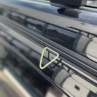 Ein schwarzes Fahrzeug mit einem gelben Haken am Fenster.