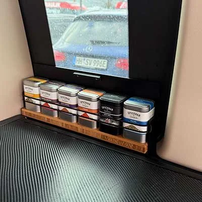 Verschiedene Gewürzdosen auf einem Holzregal an einer Fahrzeugfenster.