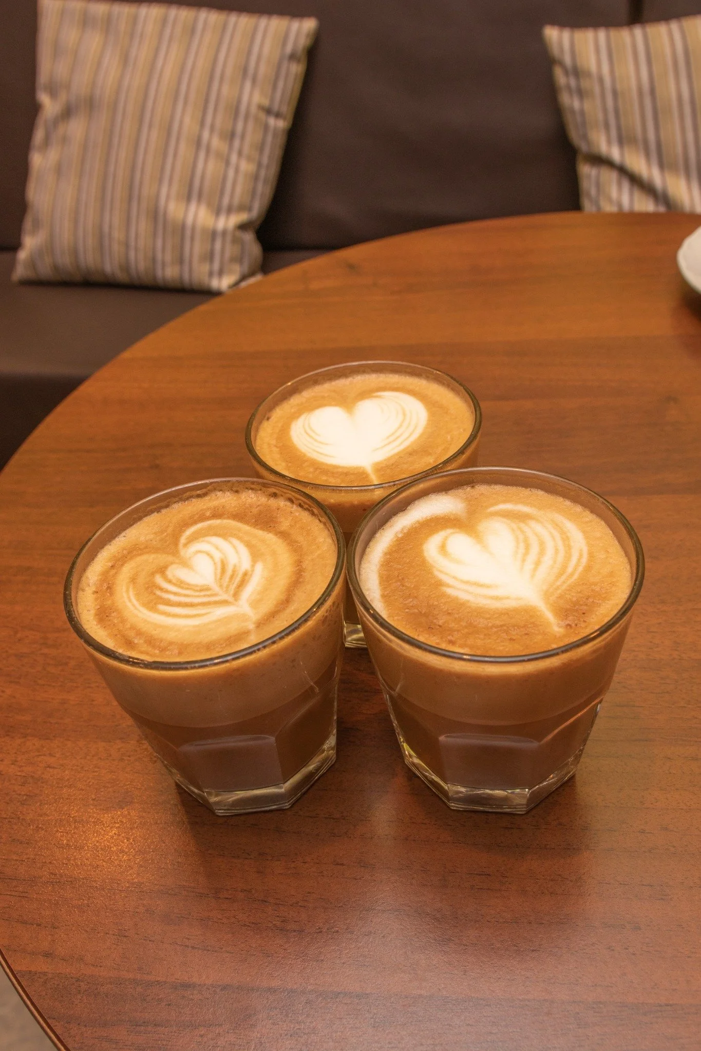 Kolme Cafe Brahen kahvia latte art -kuvioilla.