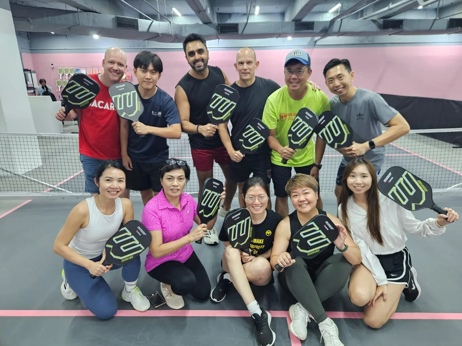 Corporate group enjoying indoor air-conditioned pickleball in Singapore