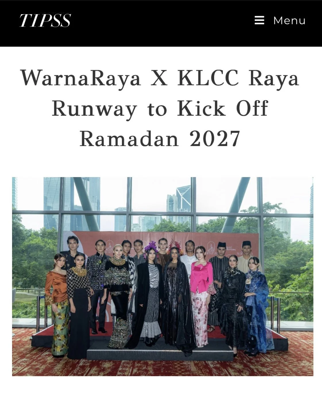 Group of models posing at a runway event for WarnaRaya X KLCC Raya Runway to Kick Off Ramadan 2027, with a backdrop of city buildings and large windows.