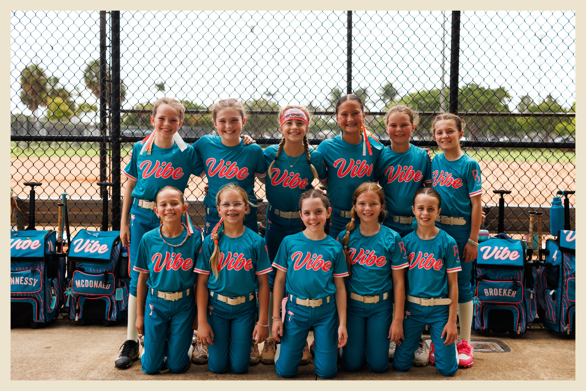 Boca Vibe 10U softball team posing together in teal uniforms beside the field.