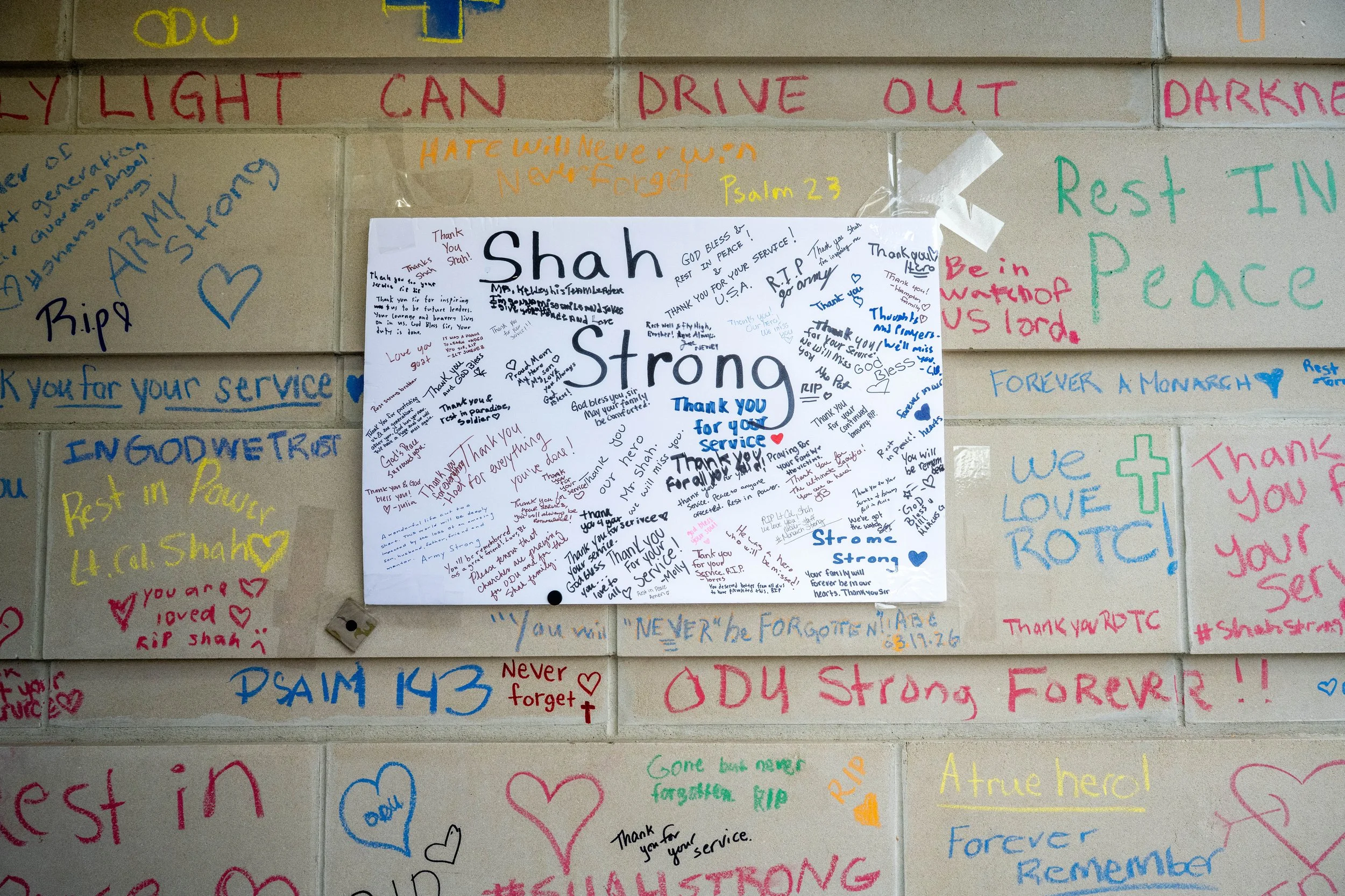 Memorial wall with handwritten messages honoring LTC Brandon A. Shah, including “Shah Strong” and “Thank you for your service.”