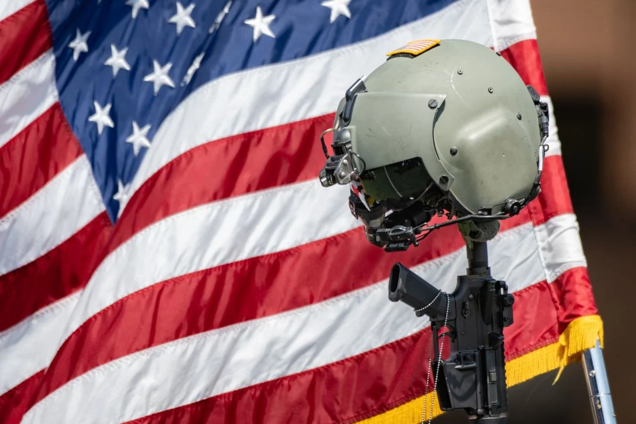 Military helmet beside an American flag at a memorial honoring LTC Brandon A. Shah.