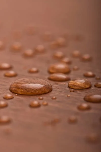 Close-up of water droplets on a wooden surface.