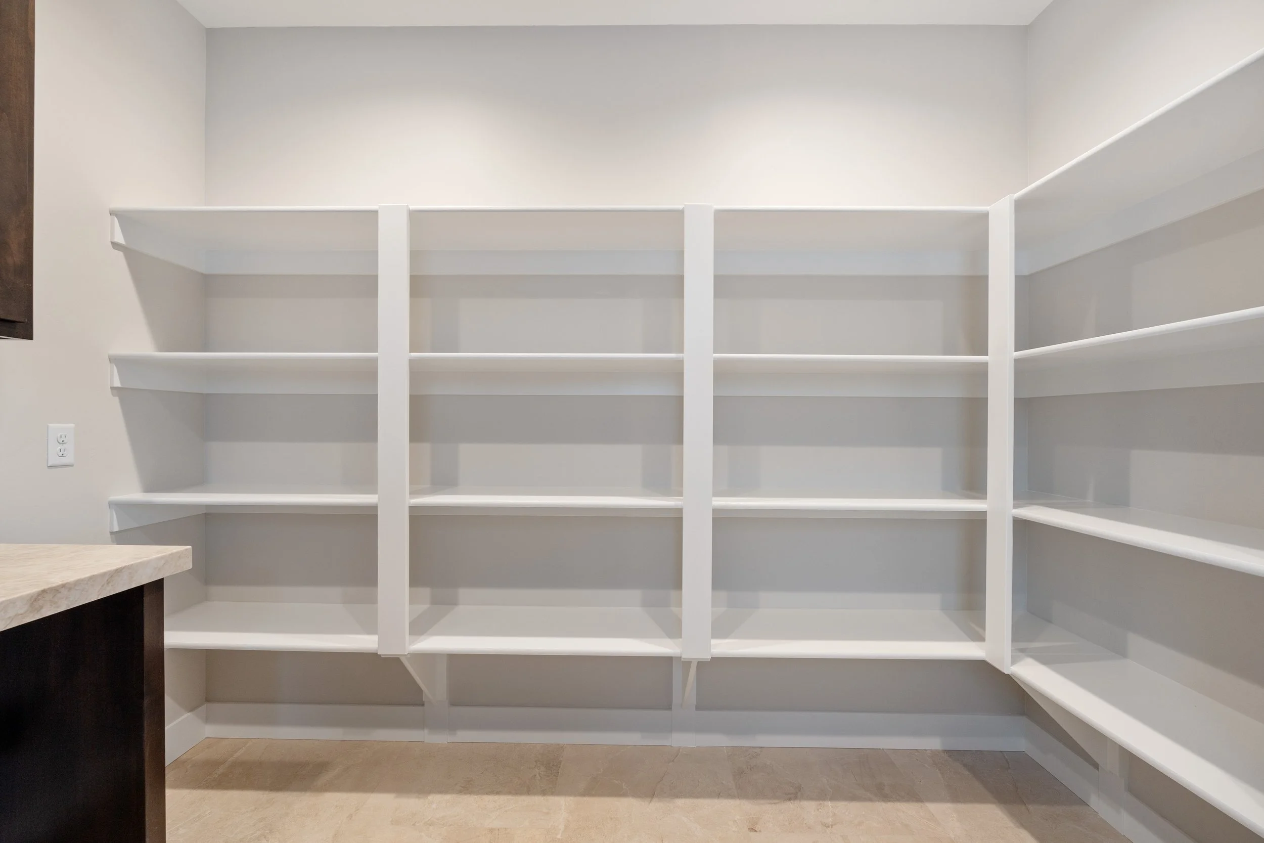 Pantry with white shelves — JAB Construction’s Timeless Craftsman custom home in Iona, Idaho.