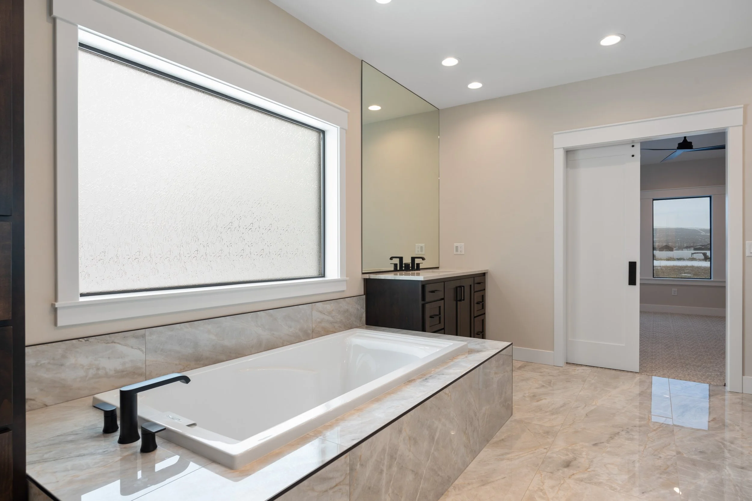 Bathroom tub beneath a broad window — JAB Construction’s Timeless Craftsman custom home in Iona, Idaho.