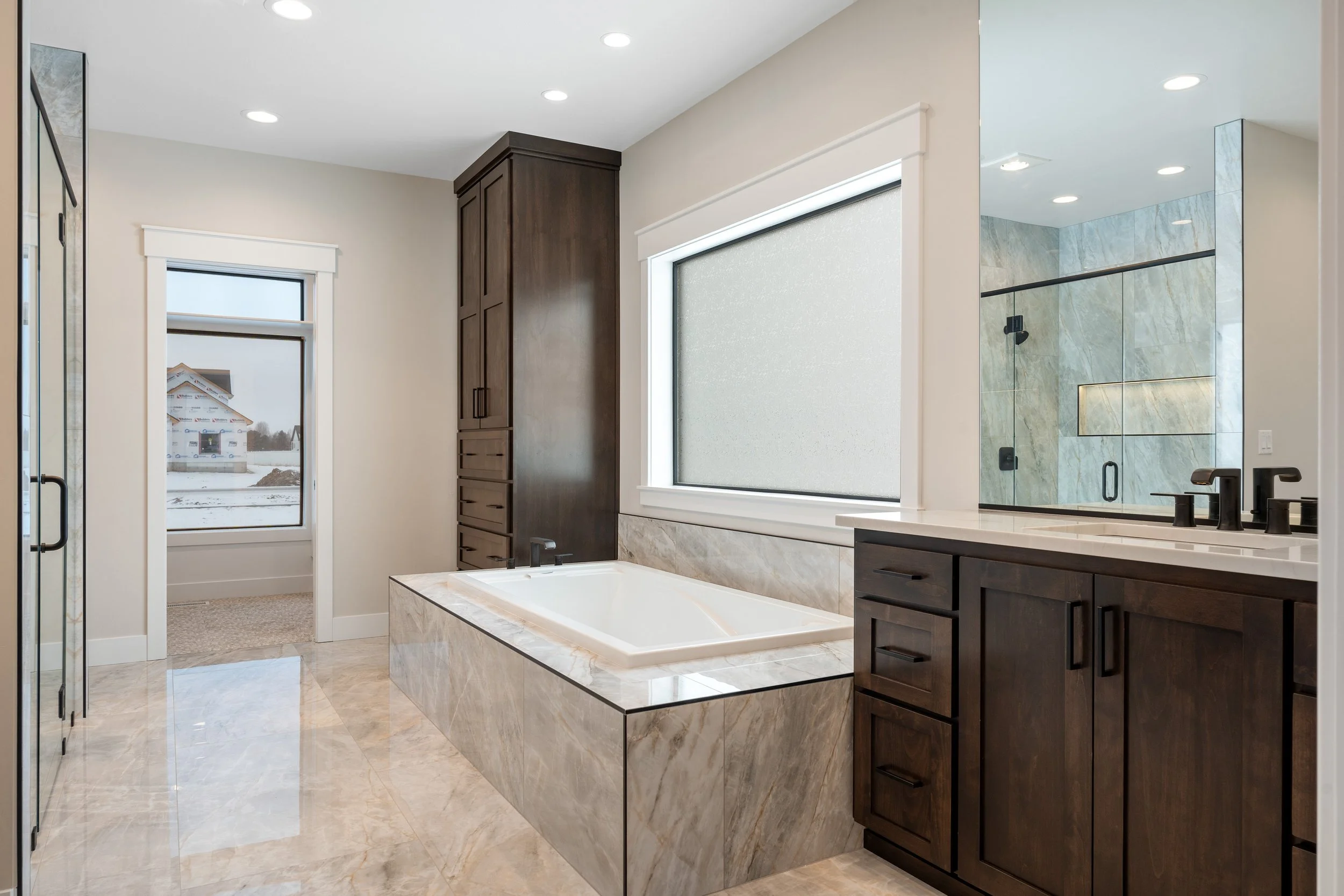 Bathroom vanity with a large mirror and wood cabinetry — JAB Construction’s Timeless Craftsman custom home in Iona, Idaho.