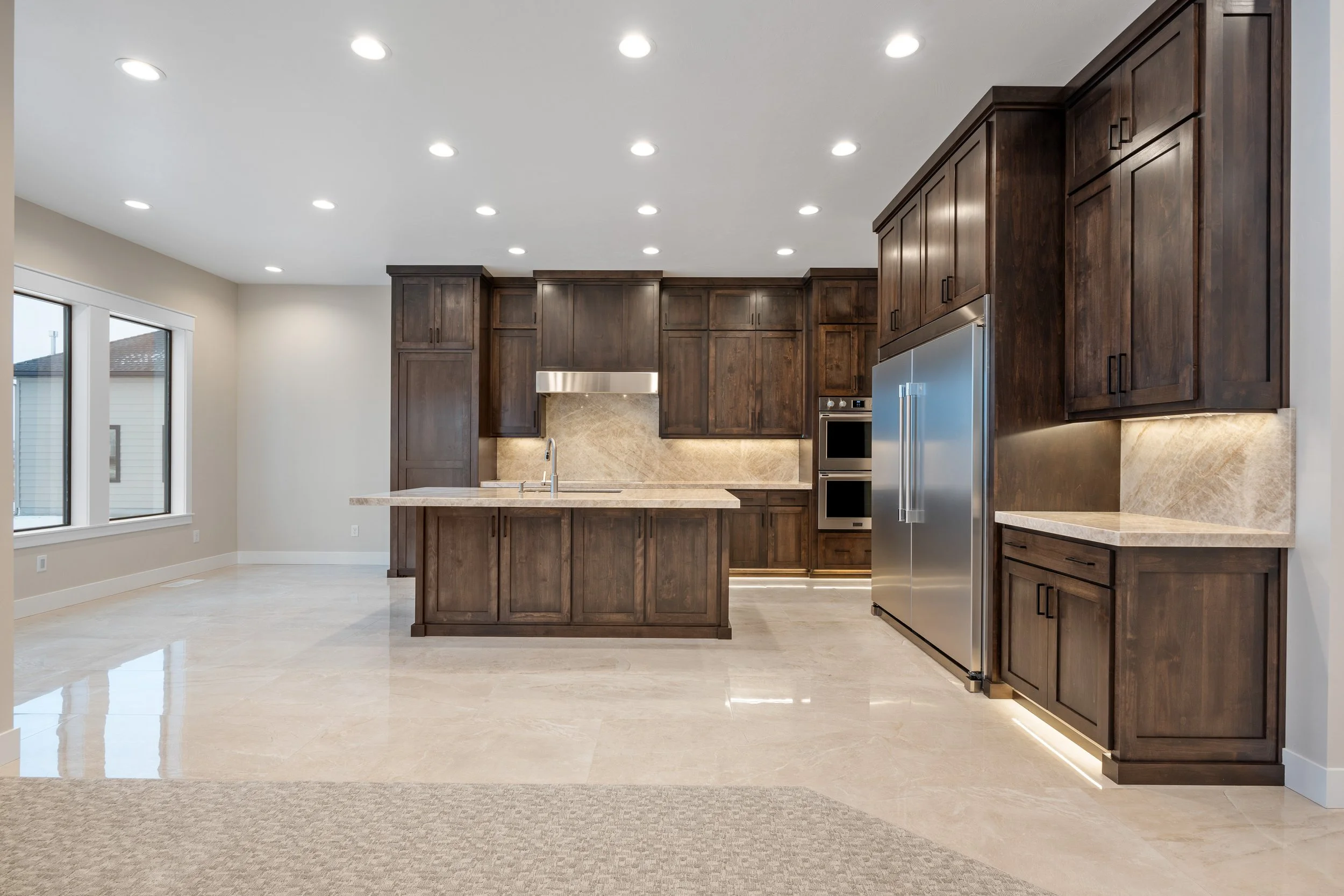 Kitchen with dark wood cabinetry and a central island — JAB Construction’s Timeless Craftsman custom home in Iona, Idaho.