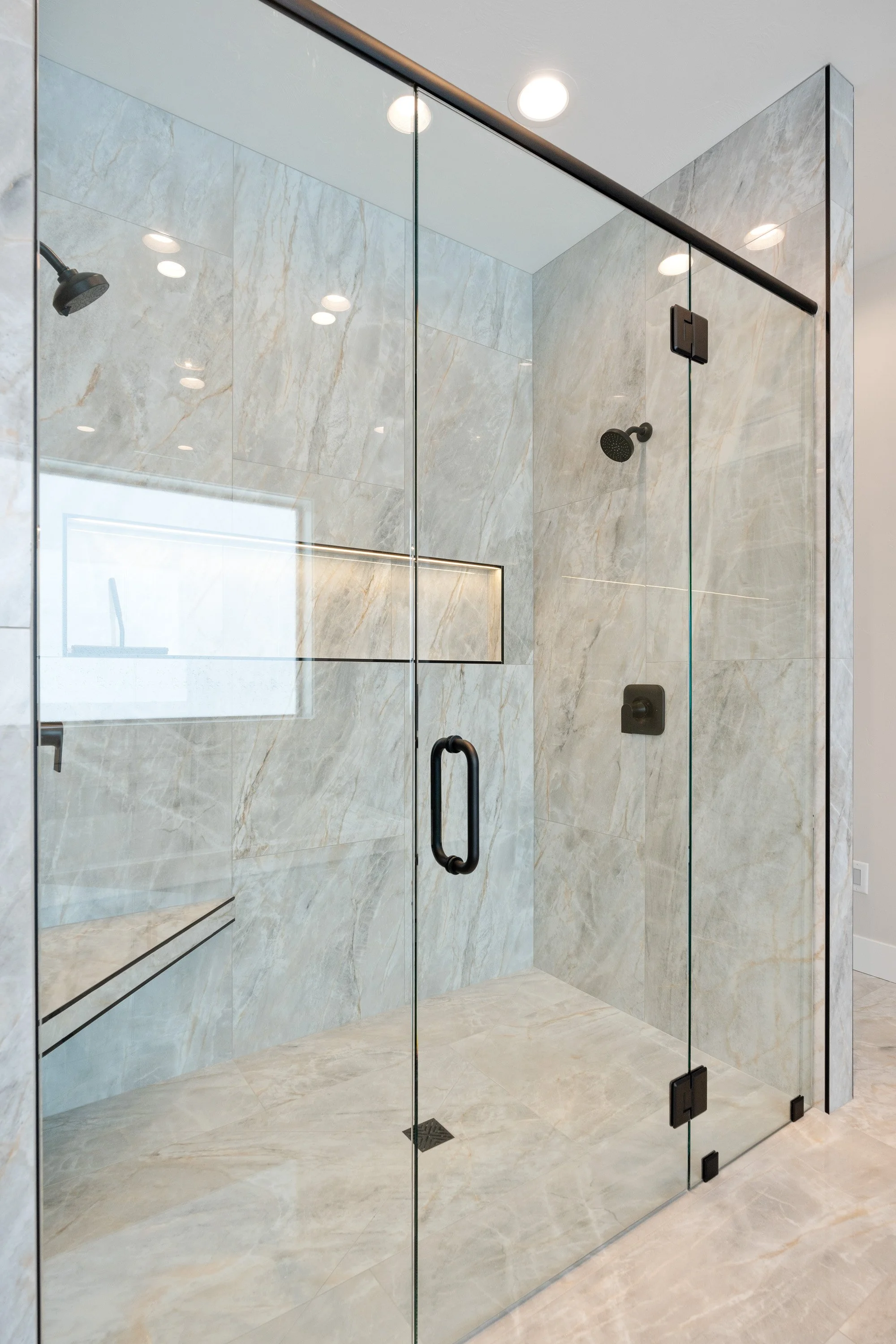 Glass-enclosed shower with tiled walls — JAB Construction’s Timeless Craftsman custom home in Iona, Idaho.