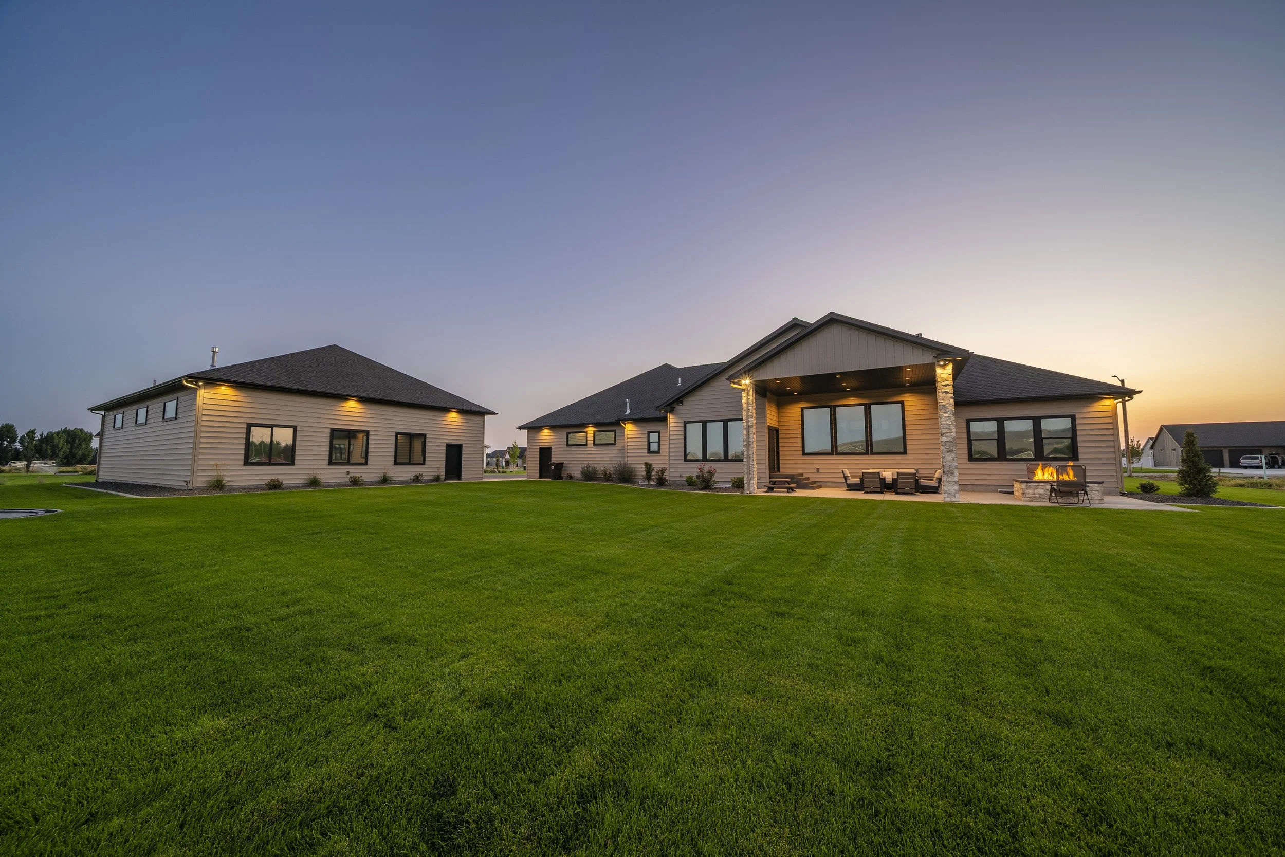 Home exterior across a landscaped lawn at dusk — JAB Construction’s Timeless Craftsman custom home in Iona, Idaho.