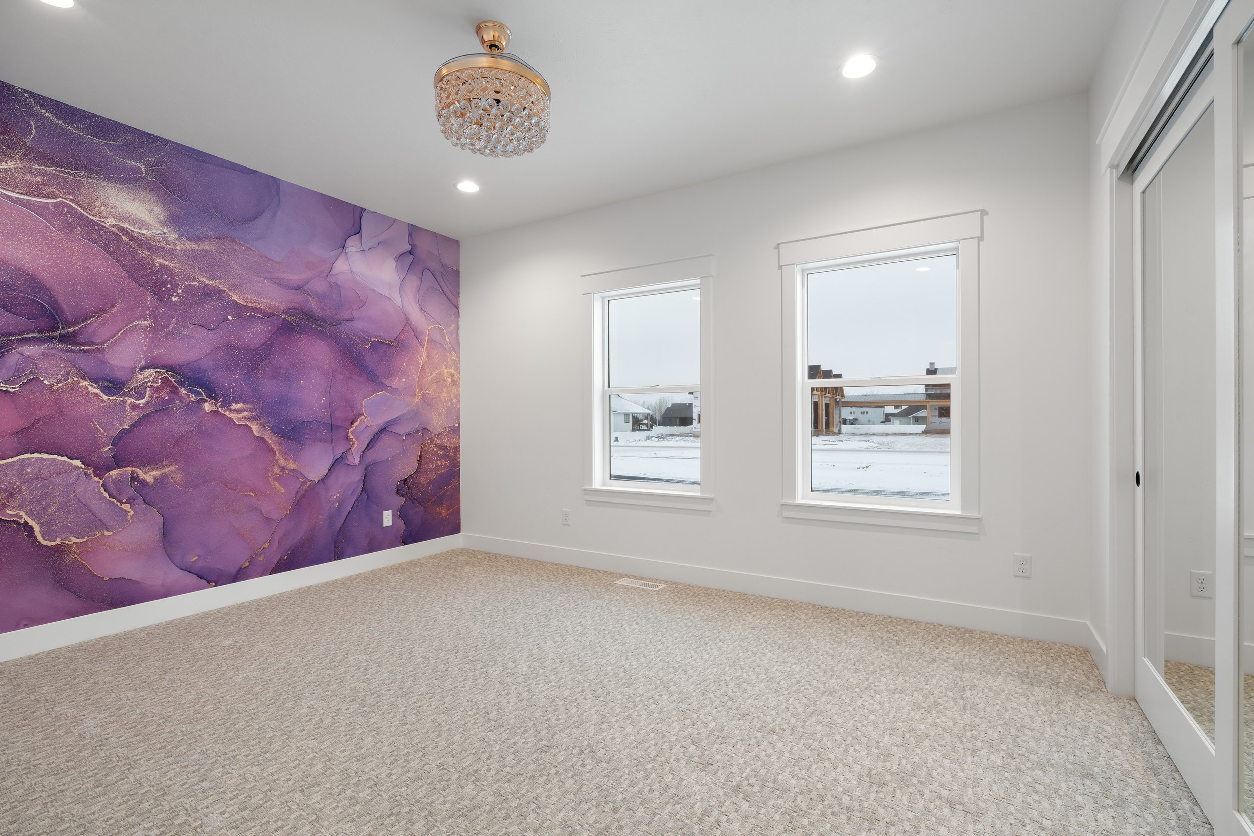 Bedroom with a purple accent wall and large windows — JAB Construction’s Timeless Craftsman custom home in Iona, Idaho.