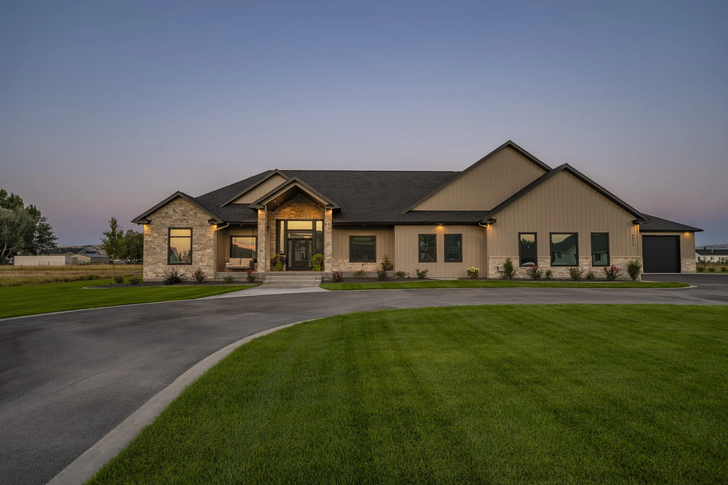 Wide front view of the home and green lawn at twilight — JAB Construction’s Timeless Craftsman custom home in Iona, Idaho.