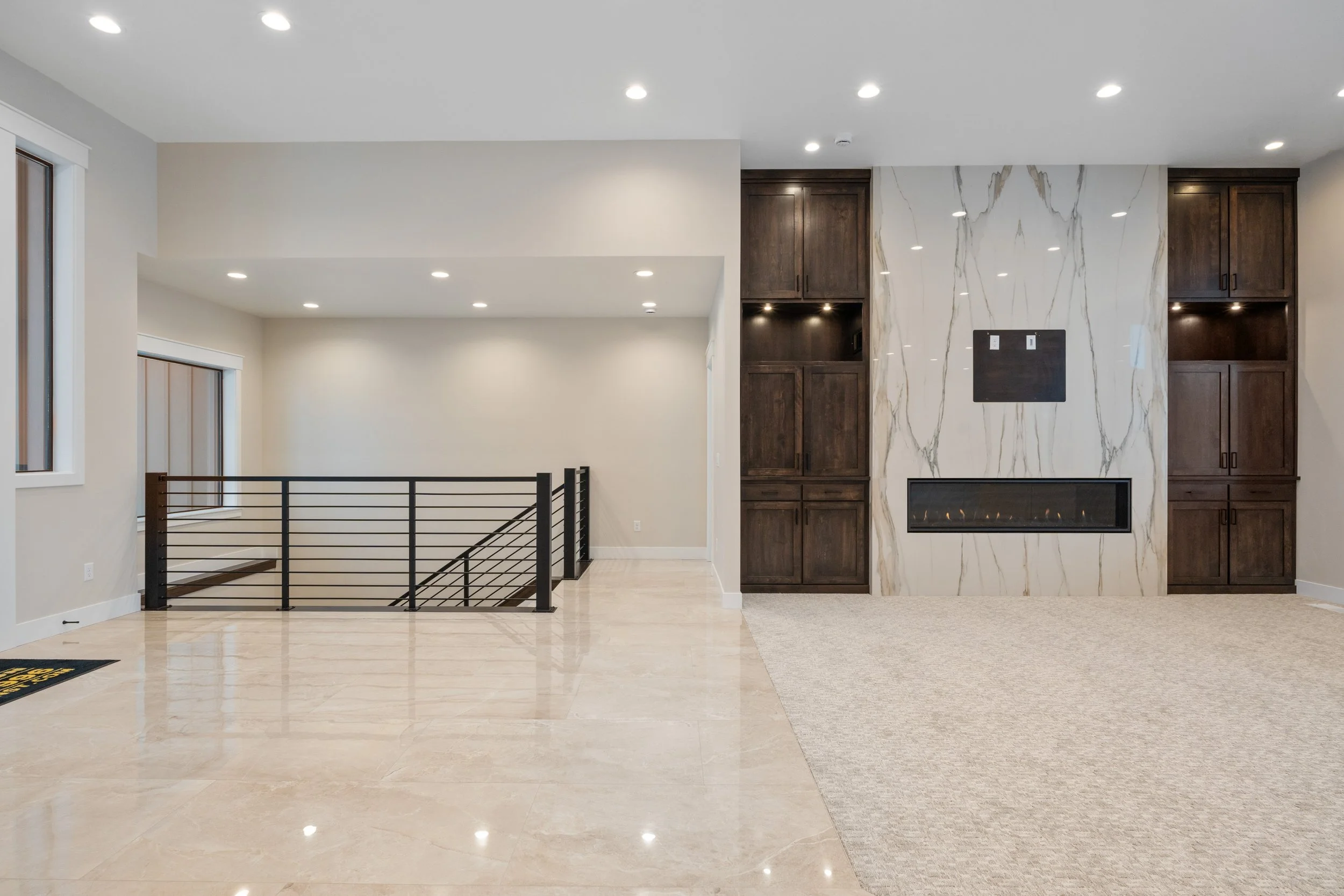 Living room with a fireplace and open stair railing — JAB Construction’s Timeless Craftsman custom home in Iona, Idaho.
