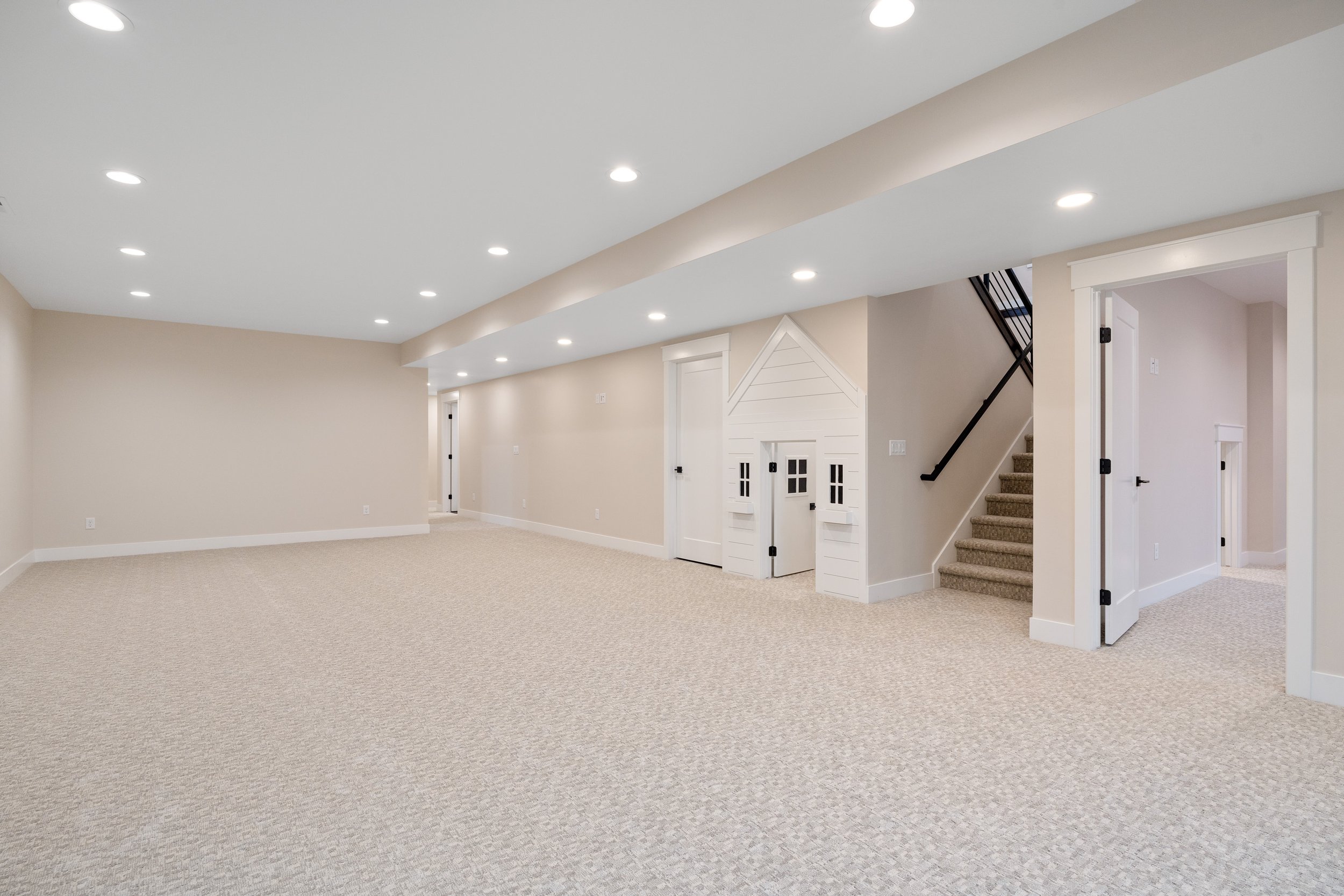 Large carpeted basement room with recessed lighting — JAB Construction’s Timeless Craftsman custom home in Iona, Idaho.