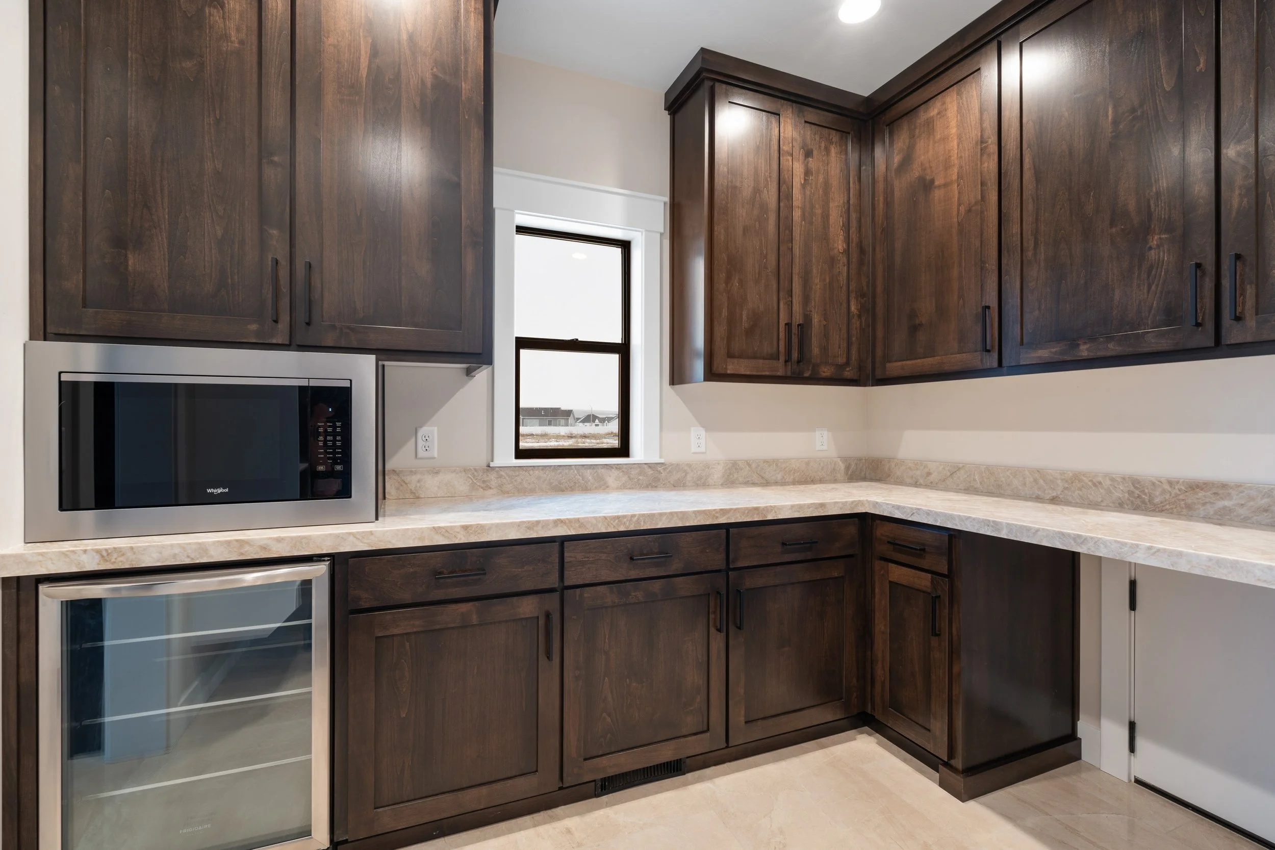 Kitchen workspace with dark wood cabinets and light counters — JAB Construction’s Timeless Craftsman custom home in Iona, Idaho.