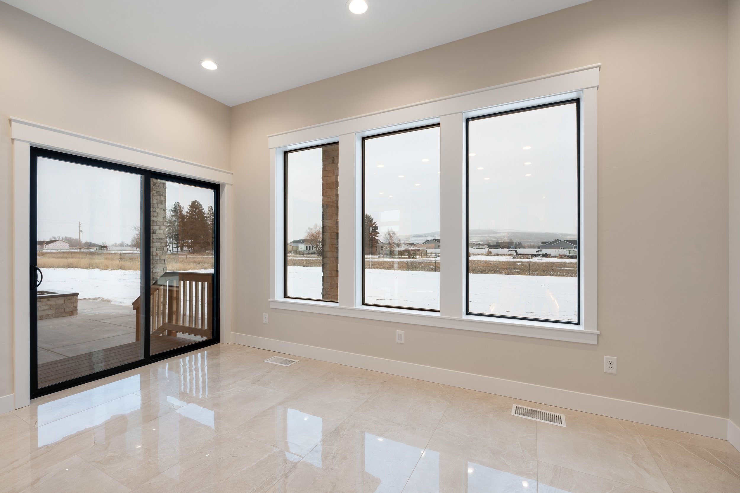 Windowed dining area with light flooring — JAB Construction’s Timeless Craftsman custom home in Iona, Idaho.
