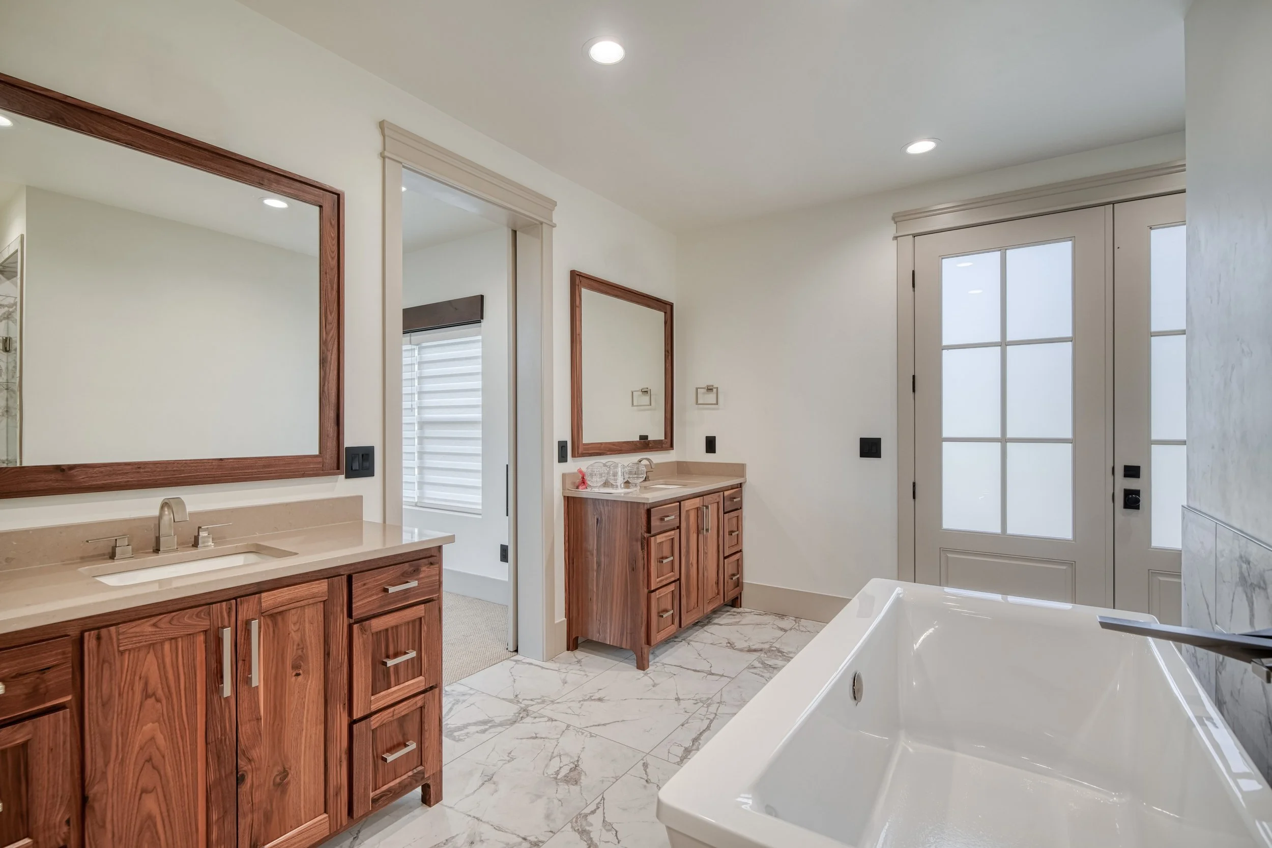 Bathroom with wood cabinetry and a freestanding tub — JAB Construction’s Modern Transitional custom home in Blackfoot, Idaho.