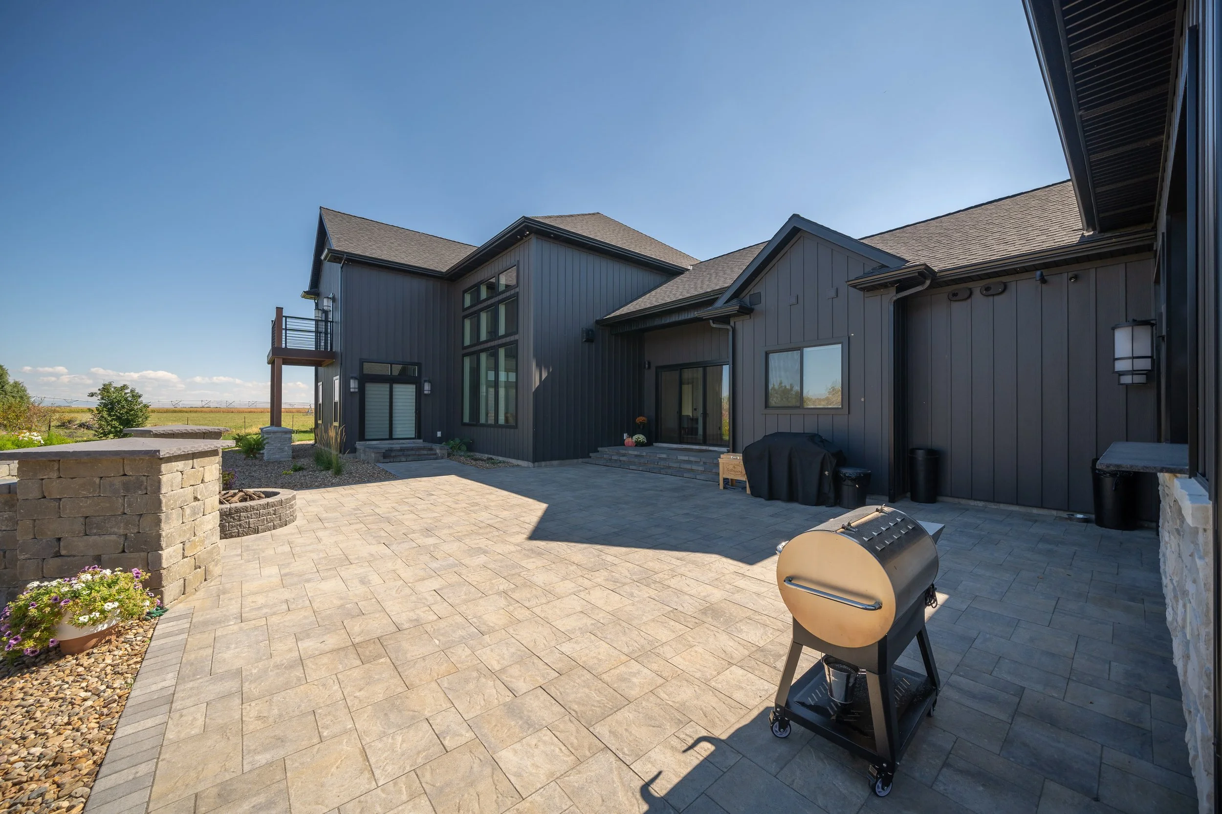 Rear home exterior beside a gravel area — JAB Construction’s Modern Transitional custom home in Blackfoot, Idaho.