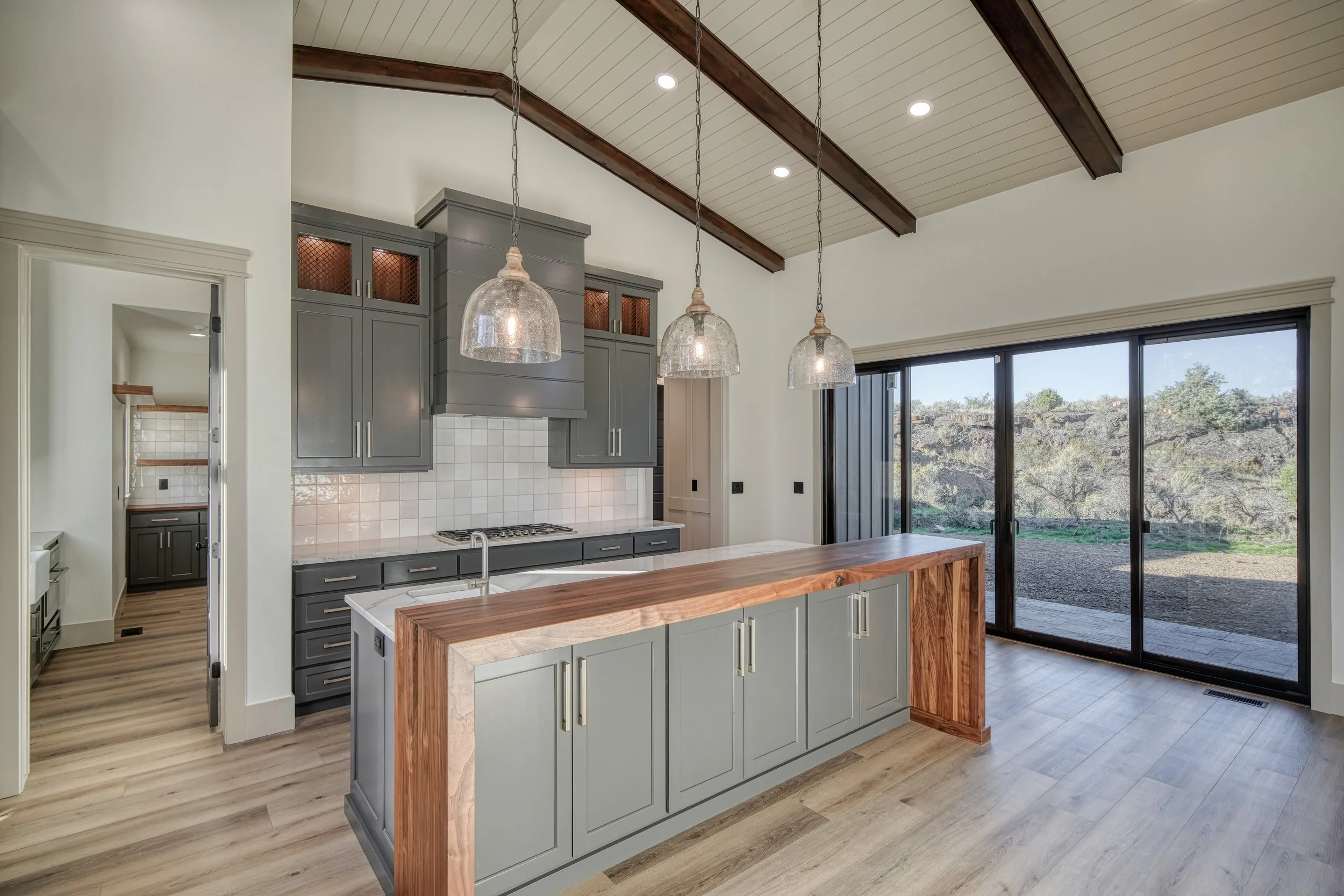 Kitchen island with contrasting wood and dark cabinetry — JAB Construction’s Modern Transitional custom home in Blackfoot, Idaho.