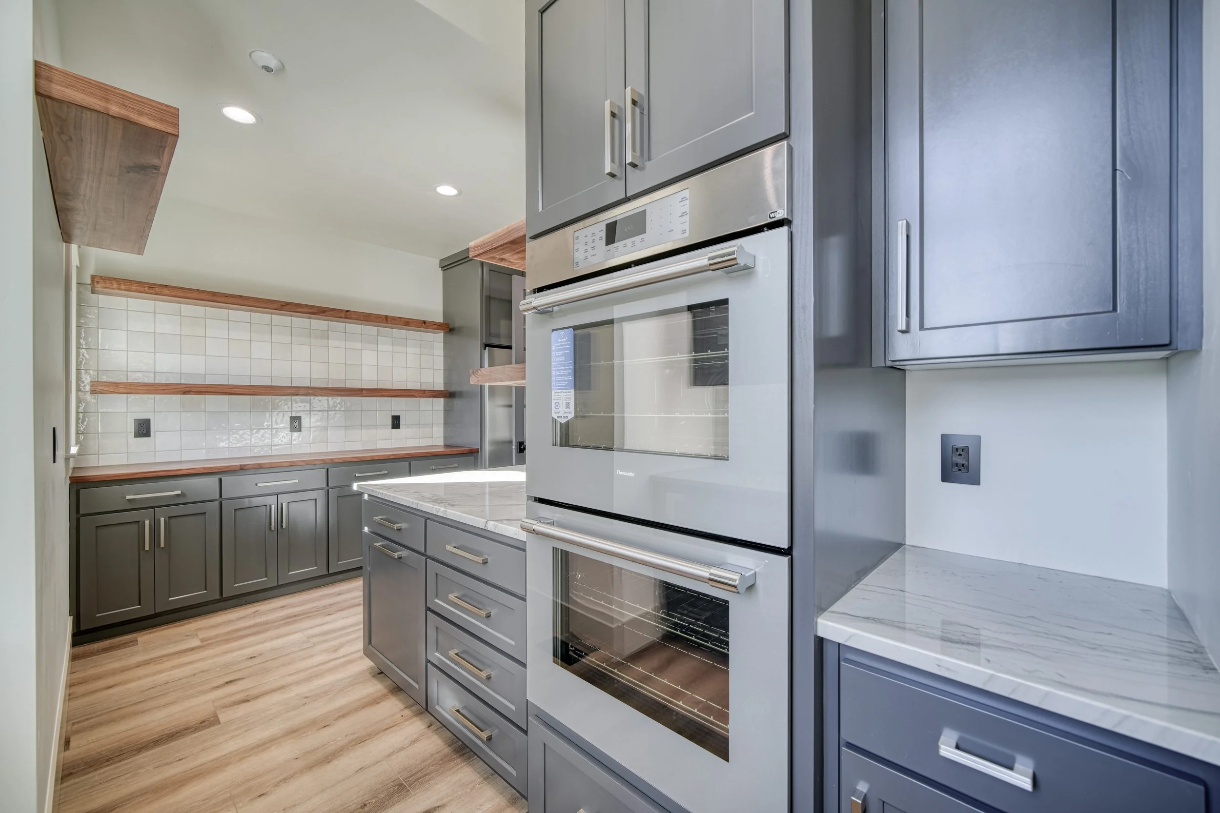 Built-in kitchen appliances framed by dark cabinets — JAB Construction’s Modern Transitional custom home in Blackfoot, Idaho.