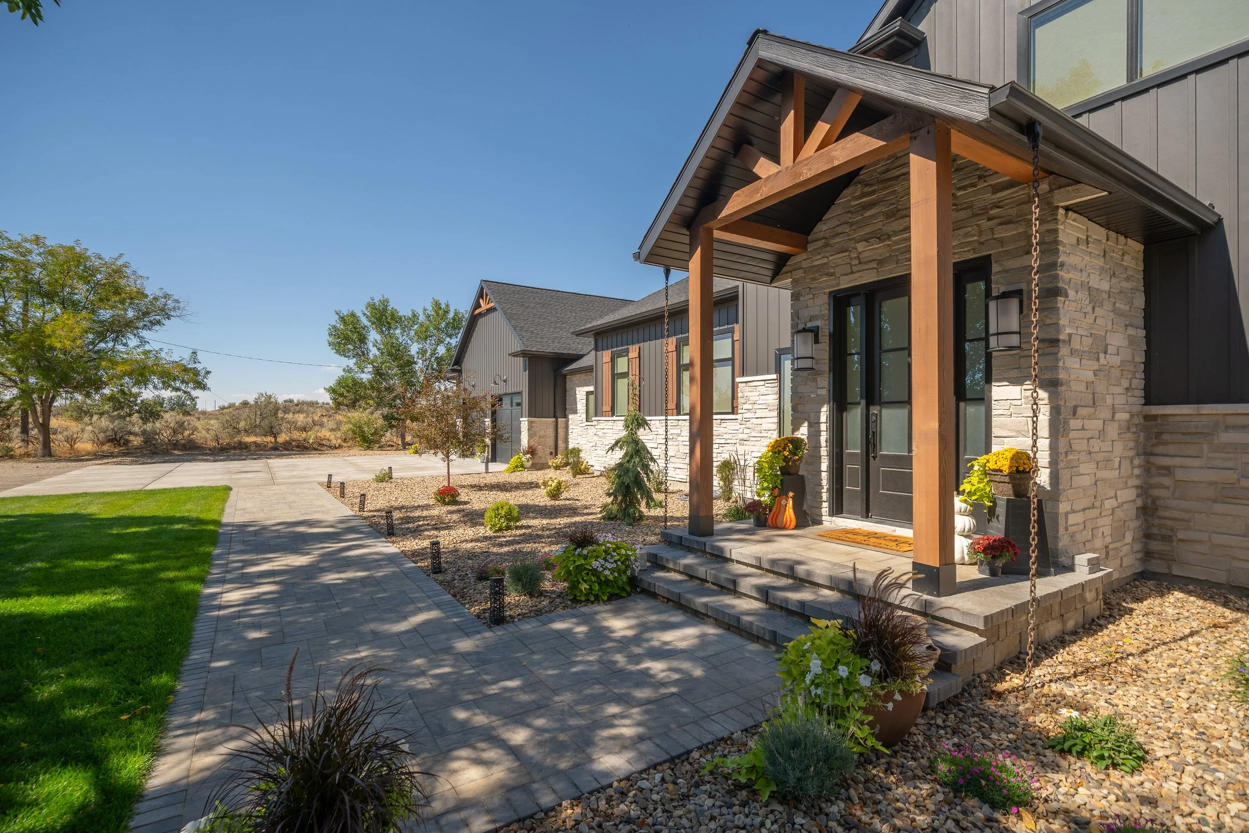 Covered front porch with timber columns and stone accents — JAB Construction’s Modern Transitional custom home in Blackfoot, Idaho.