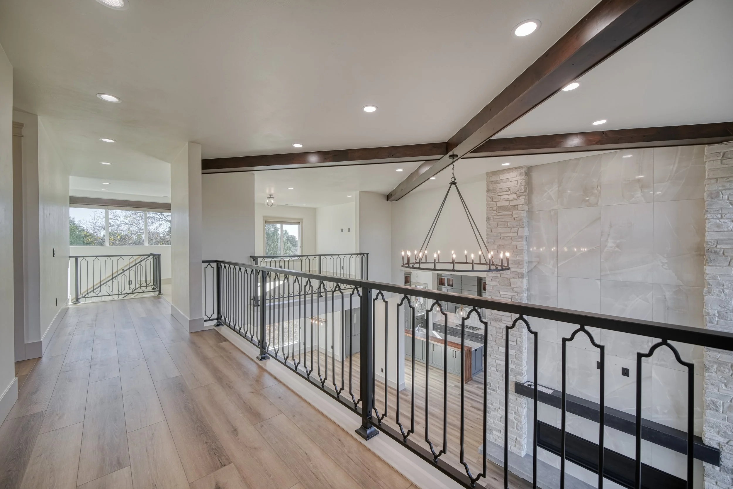 Upper landing with exposed ceiling beams and metal railings — JAB Construction’s Modern Transitional custom home in Blackfoot, Idaho.