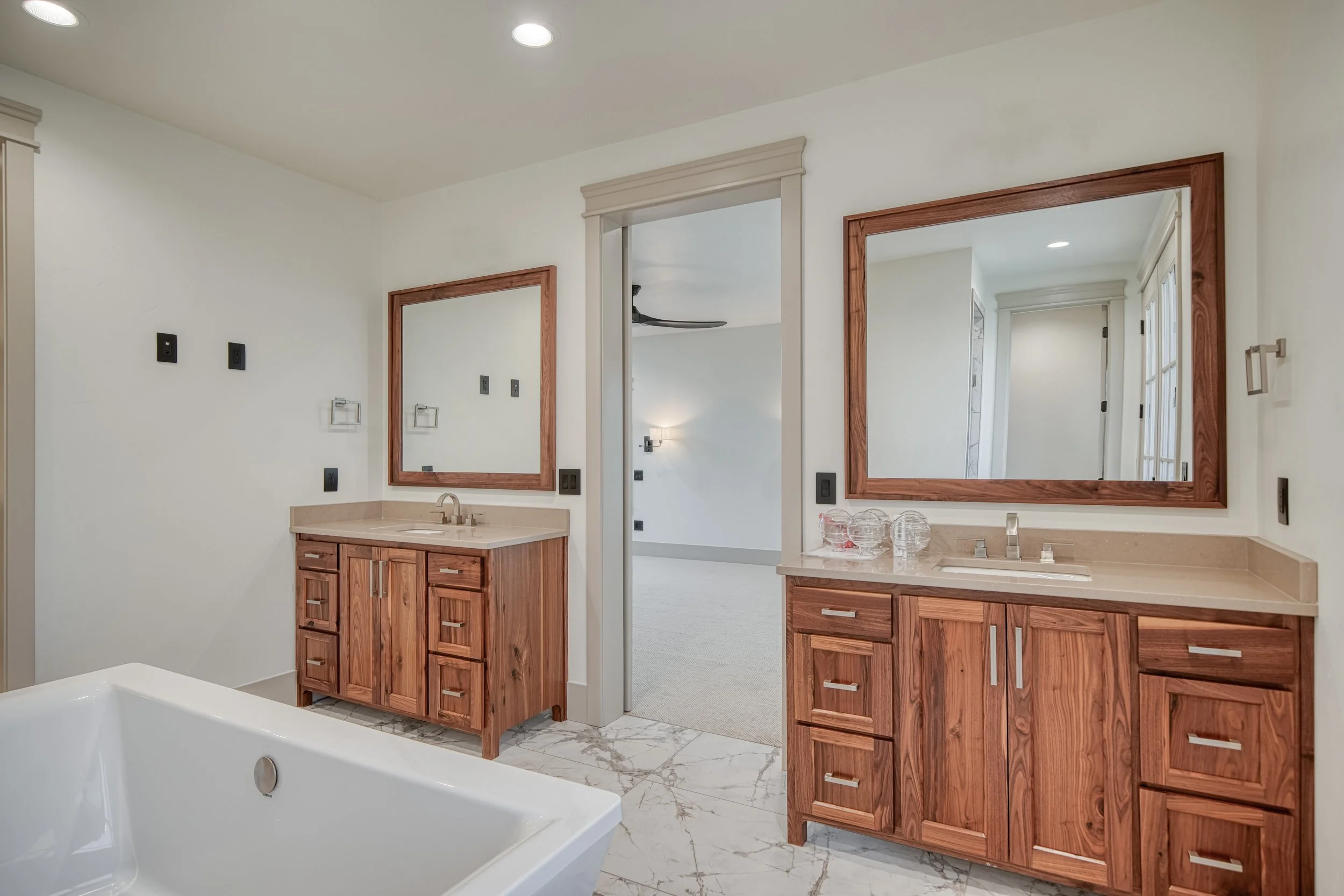 Bathroom with twin wood vanities and framed mirrors — JAB Construction’s Modern Transitional custom home in Blackfoot, Idaho.