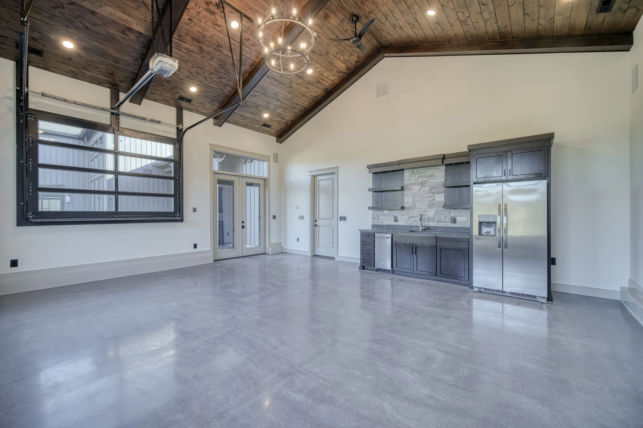 Garage workspace with wood ceiling beams and storage cabinets — JAB Construction’s Modern Transitional custom home in Blackfoot, Idaho.