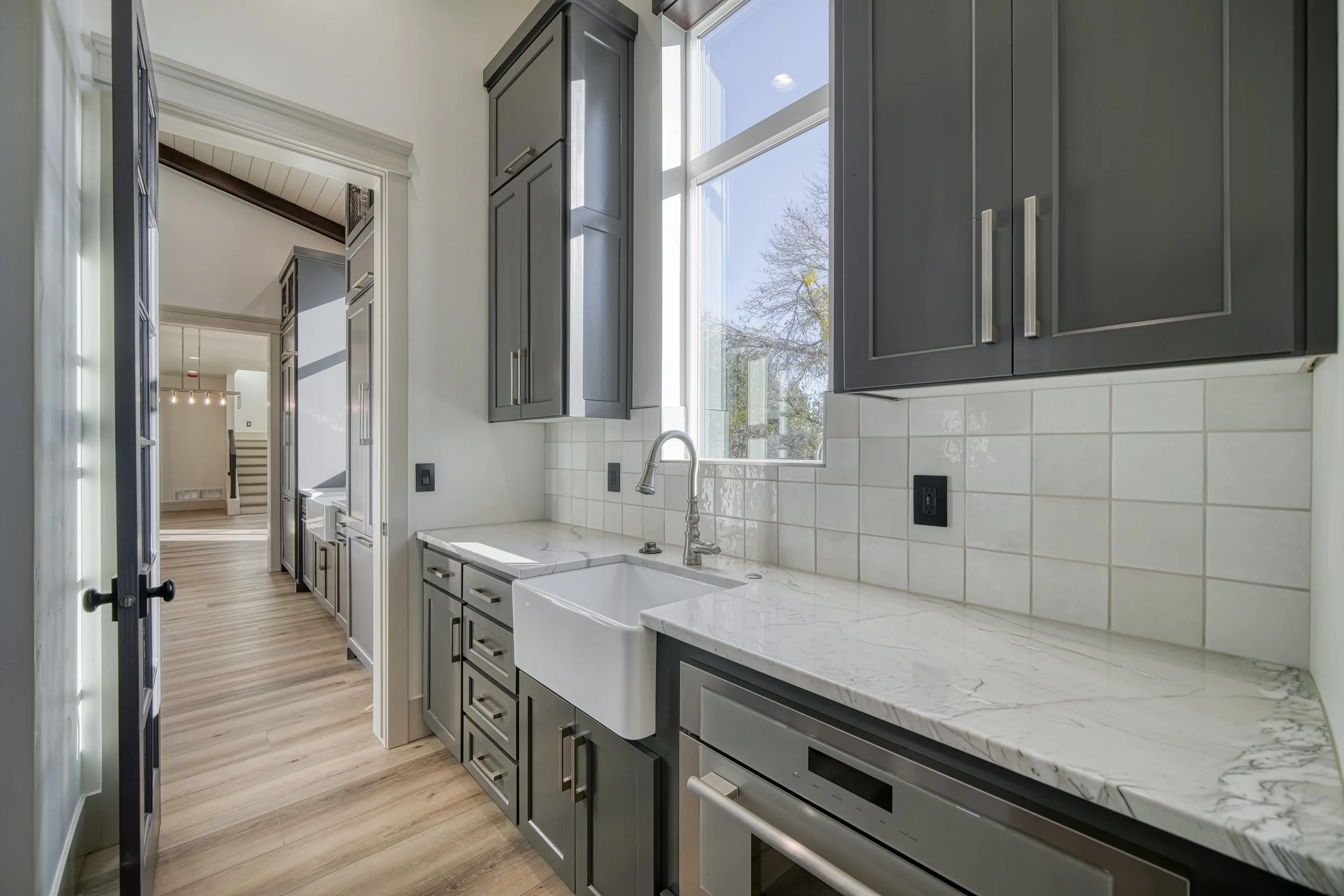 Kitchen sink below a window with dark cabinetry — JAB Construction’s Modern Transitional custom home in Blackfoot, Idaho.