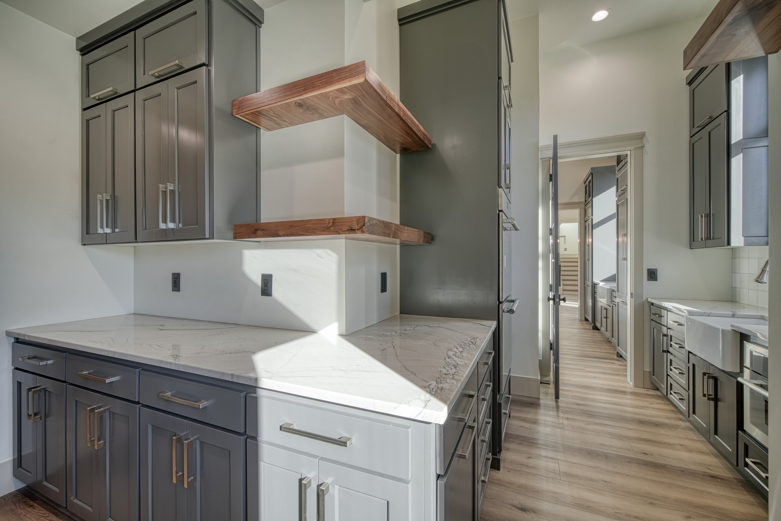 Pantry workspace with a sink and floating wood shelves — JAB Construction’s Modern Transitional custom home in Blackfoot, Idaho.