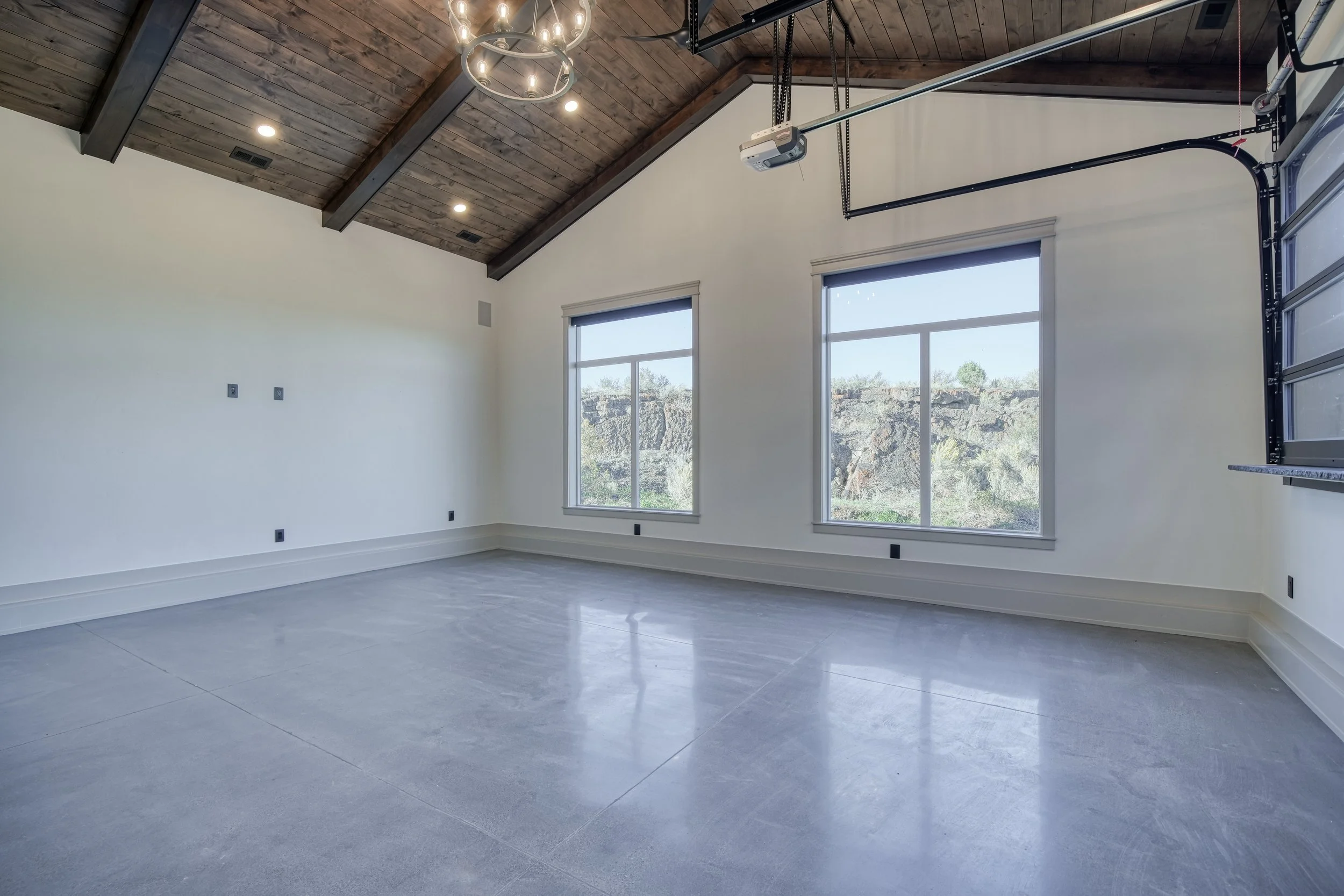 Garage interior with exposed wood ceiling and large windows — JAB Construction’s Modern Transitional custom home in Blackfoot, Idaho.