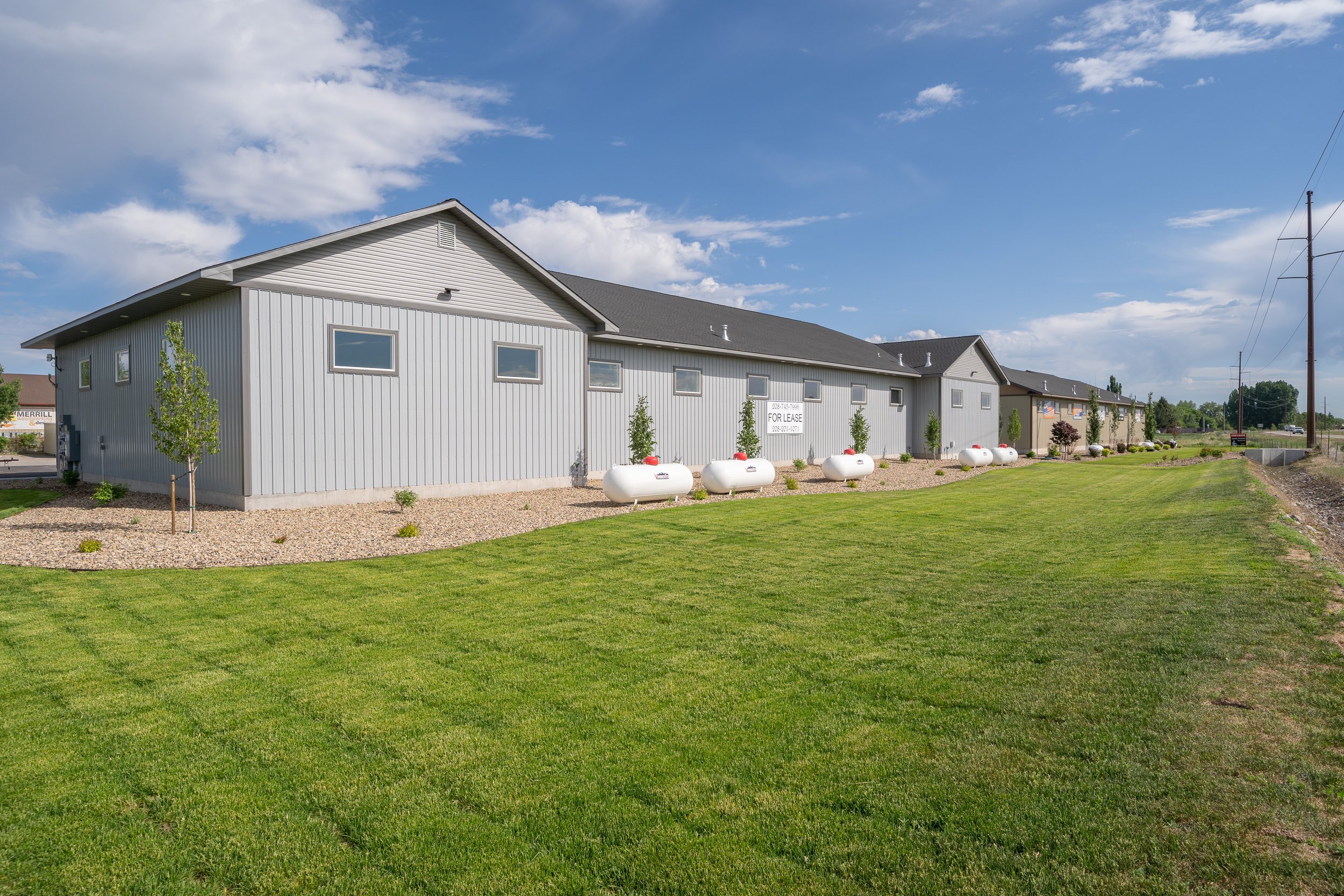 Rear exterior of a commercial building beside grass — JAB Construction’s Commercial Lease Space project in Rigby, Idaho.