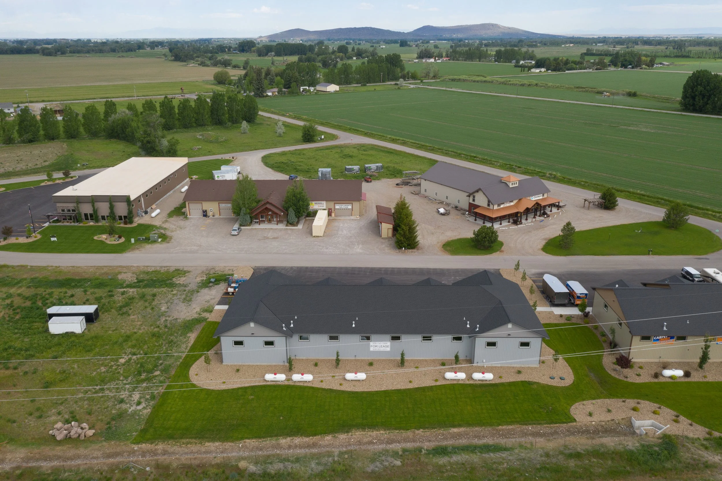 Overhead view of a commercial building, parking lot and nearby fields — JAB Construction’s Commercial Lease Space project in Rigby, Idaho.