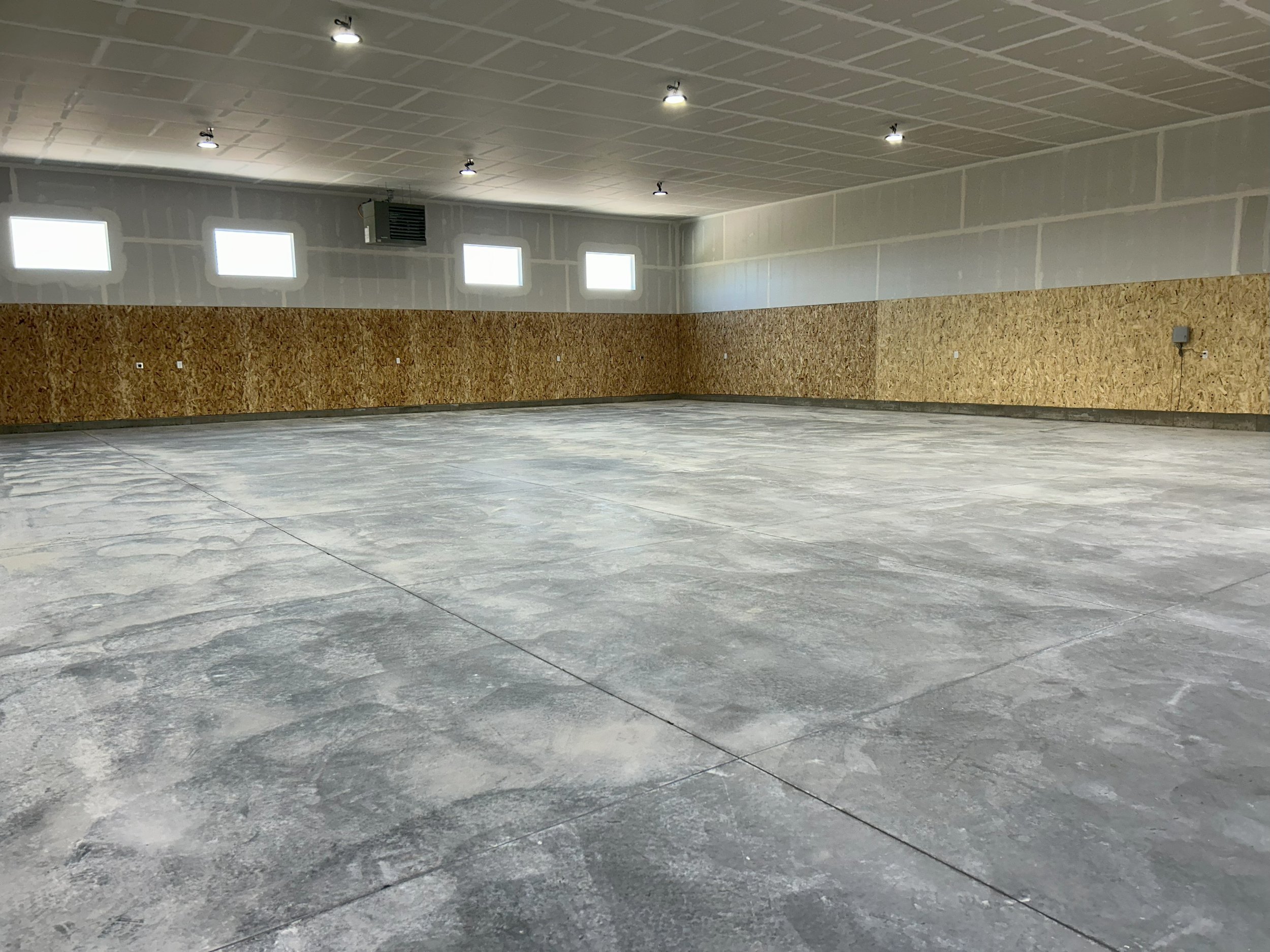 Commercial garage interior with wall-mounted windows — JAB Construction’s Modern Commercial Lease Space project in Rigby, Idaho.