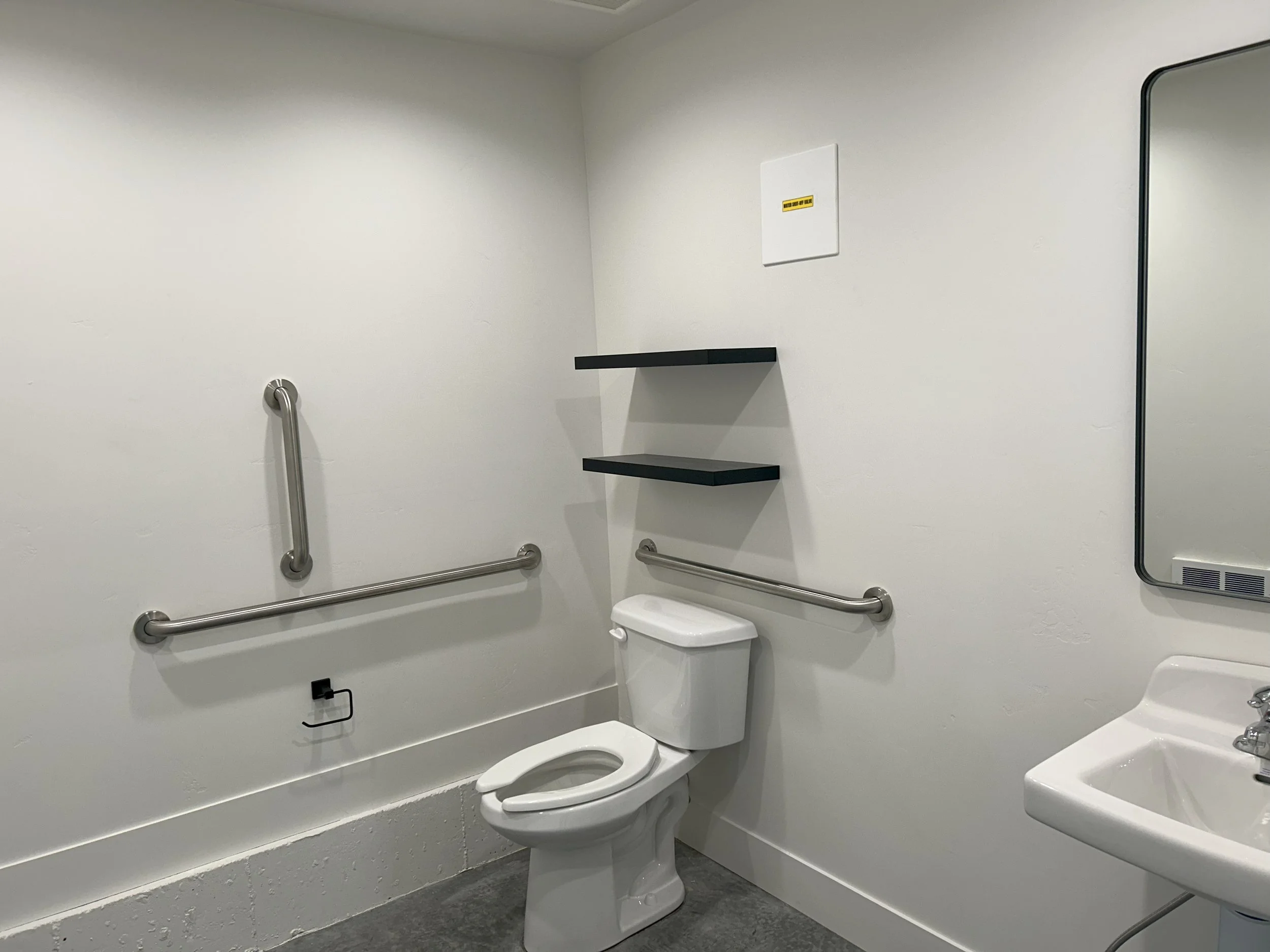 Bathroom with a toilet and sink — JAB Construction’s Modern Commercial Lease Space project in Rigby, Idaho.
