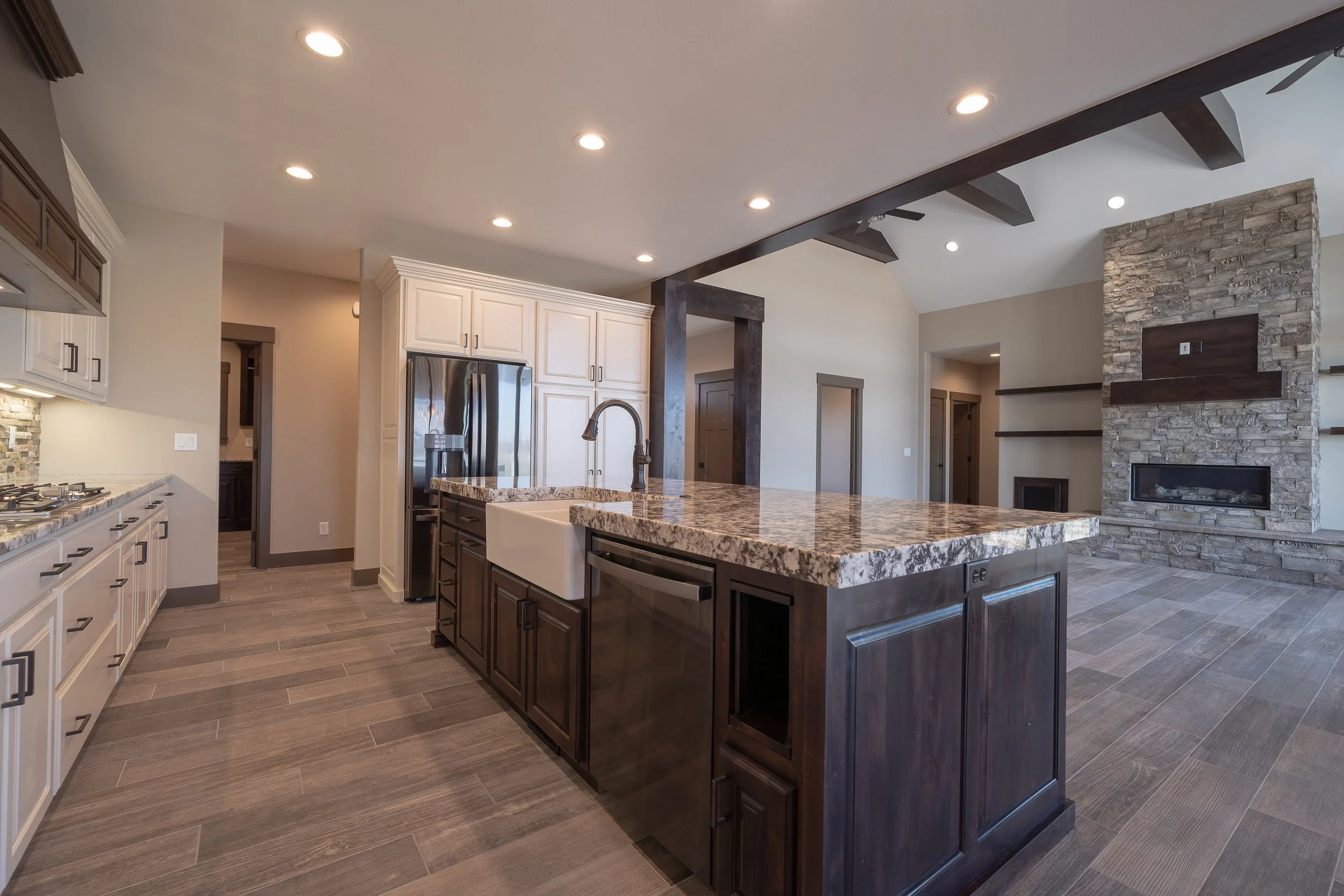Kitchen with dark cabinetry and a large island — JAB Construction’s Stone Craftsman custom home in Roberts, Idaho.