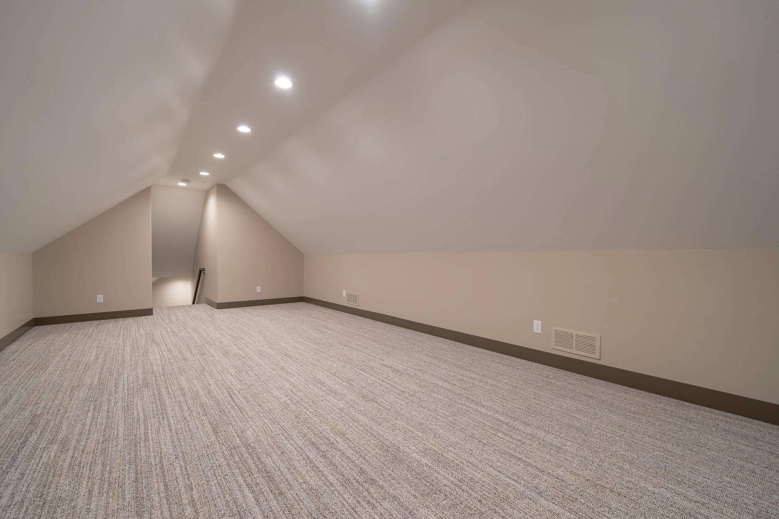 Long carpeted room with a sloped ceiling — JAB Construction’s Stone Craftsman custom home in Roberts, Idaho.