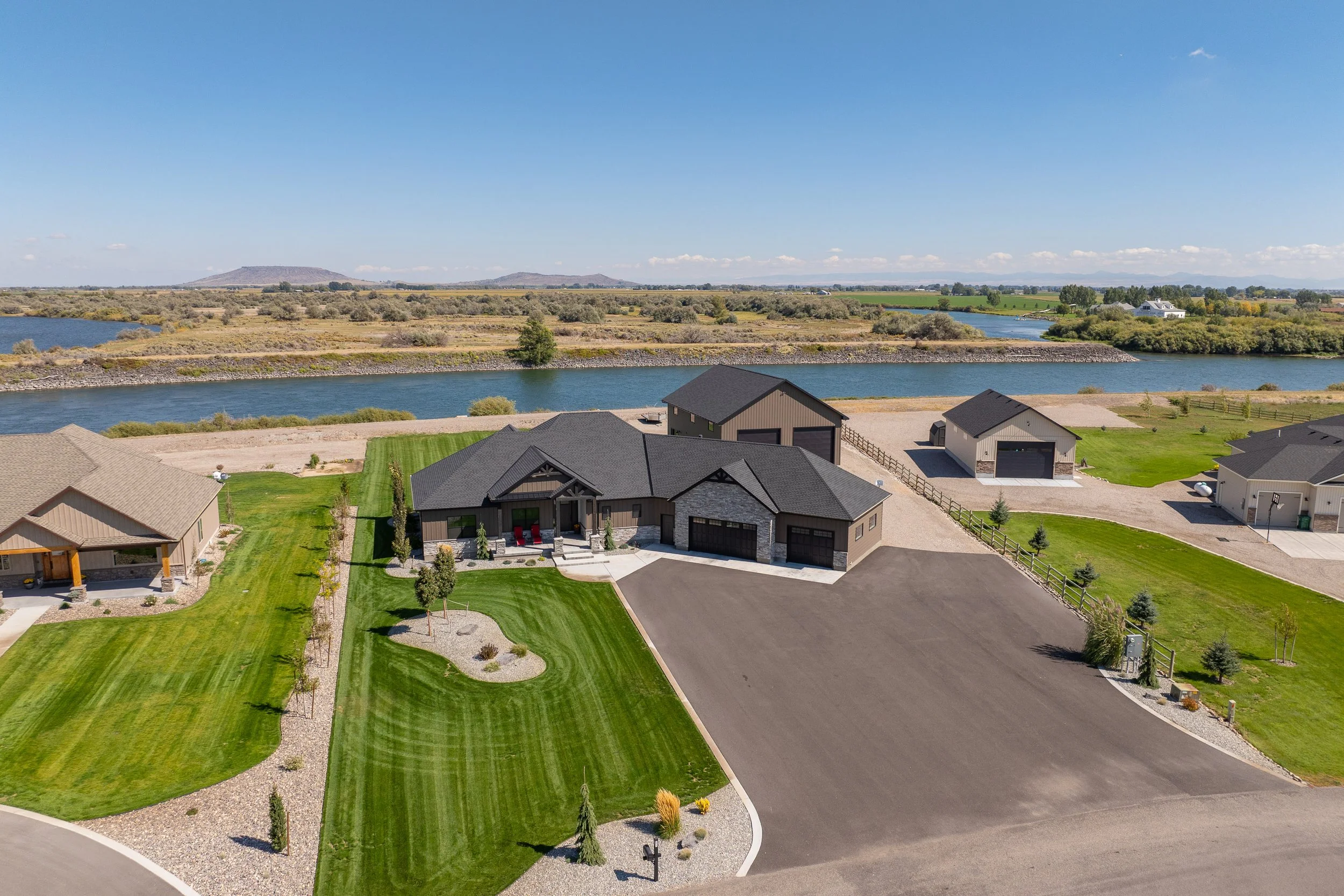 Aerial view of the home and paved driveway — JAB Construction’s Stone Craftsman custom home in Roberts, Idaho.