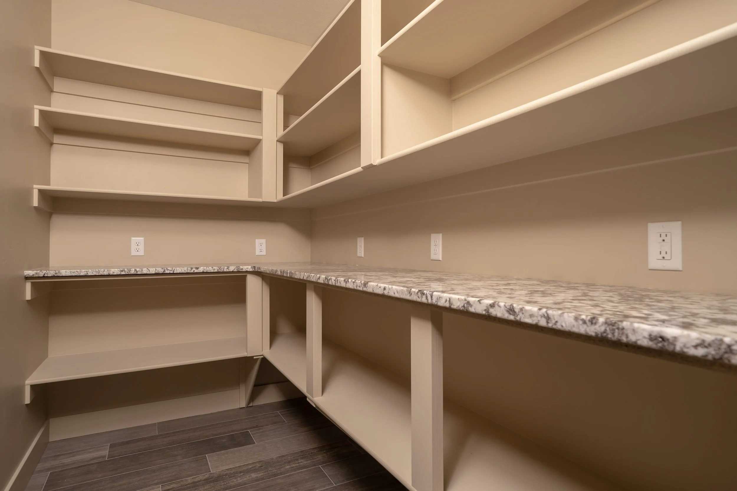 Walk-in closet with built-in shelves and countertop — JAB Construction’s Stone Craftsman custom home in Roberts, Idaho.