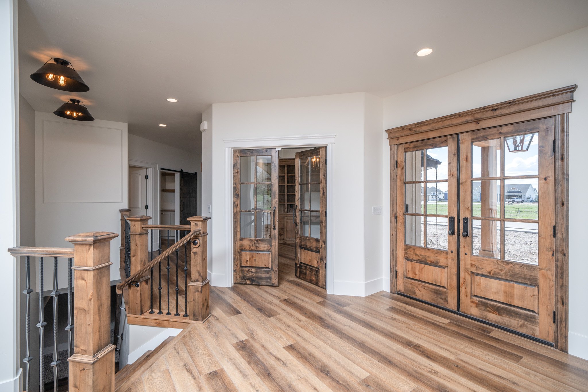 Entry area with wood doors, cabinetry and wood flooring — JAB Construction’s Modern Rustic custom home in Idaho Falls, Idaho.