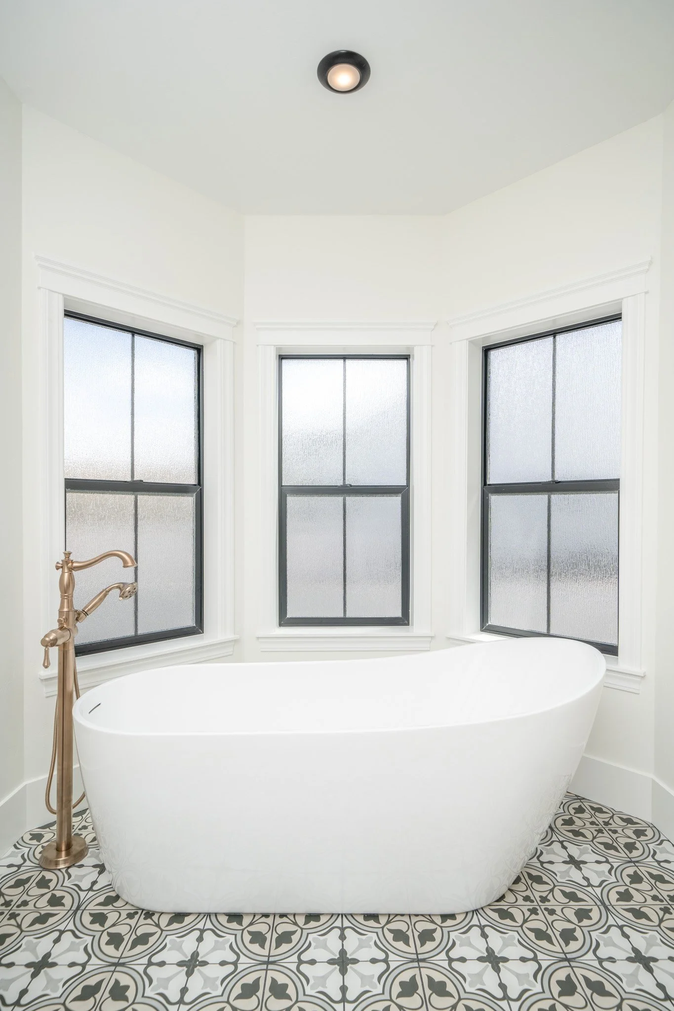 Freestanding tub beneath three windows — JAB Construction’s Modern Rustic custom home in Idaho Falls, Idaho.