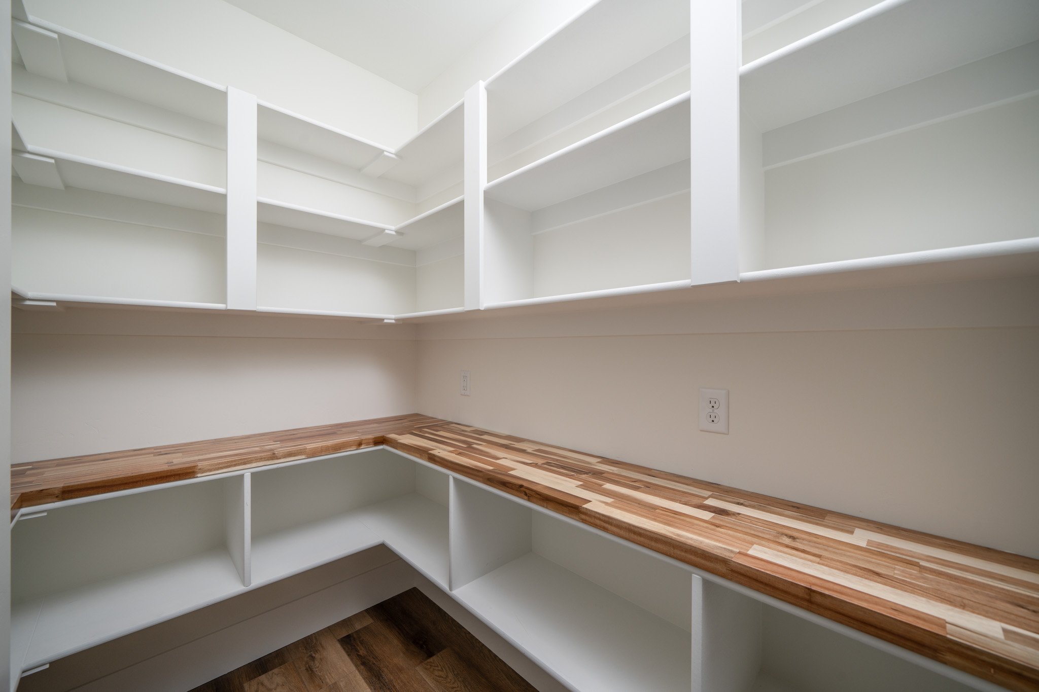 Stair landing with wood railings and recessed lighting — JAB Construction’s Modern Rustic custom home in Idaho Falls, Idaho.