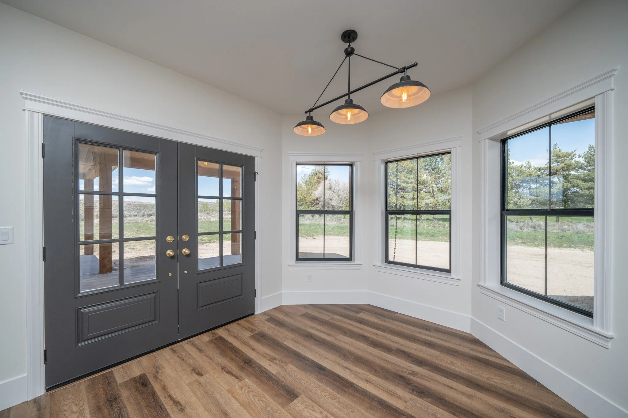 Windowed dining area beside glass doors — JAB Construction’s Modern Rustic custom home in Idaho Falls, Idaho.