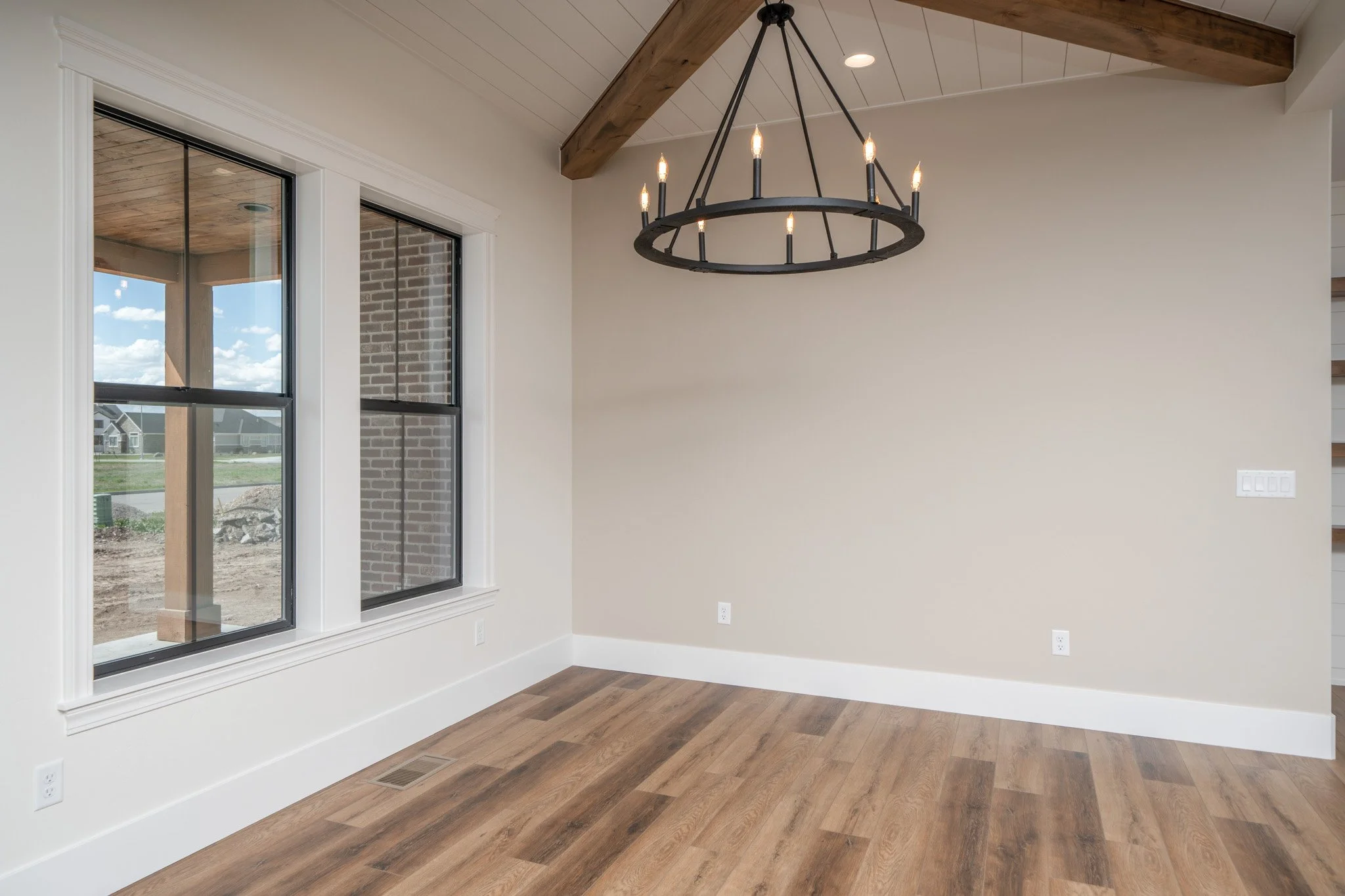 Room with wood flooring, ceiling beams and a geometric pendant light — JAB Construction’s Modern Rustic custom home in Idaho Falls, Idaho.