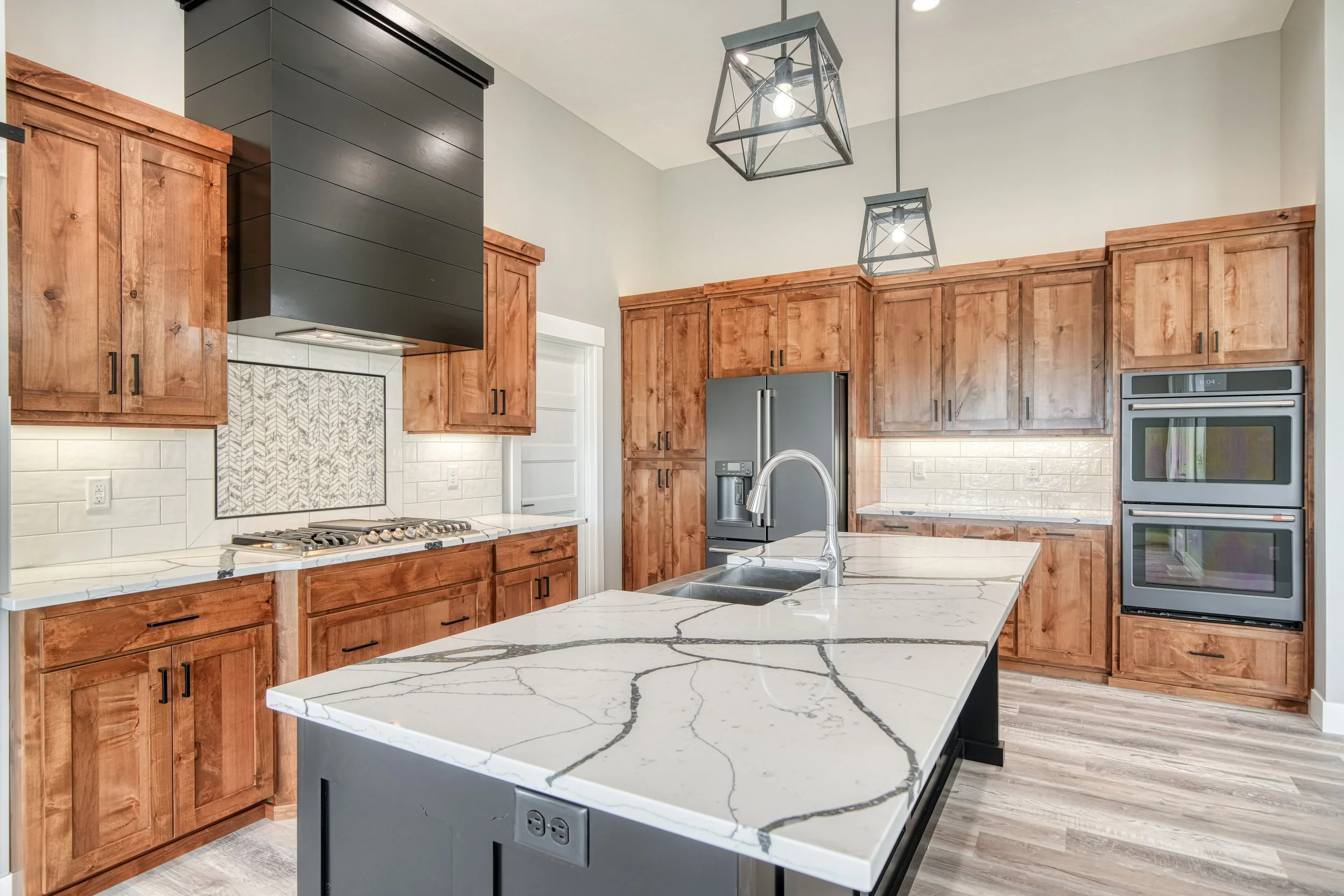 Kitchen island with a light countertop and wood cabinetry — JAB Construction’s Modern Craftsman custom home in Idaho Falls, Idaho.