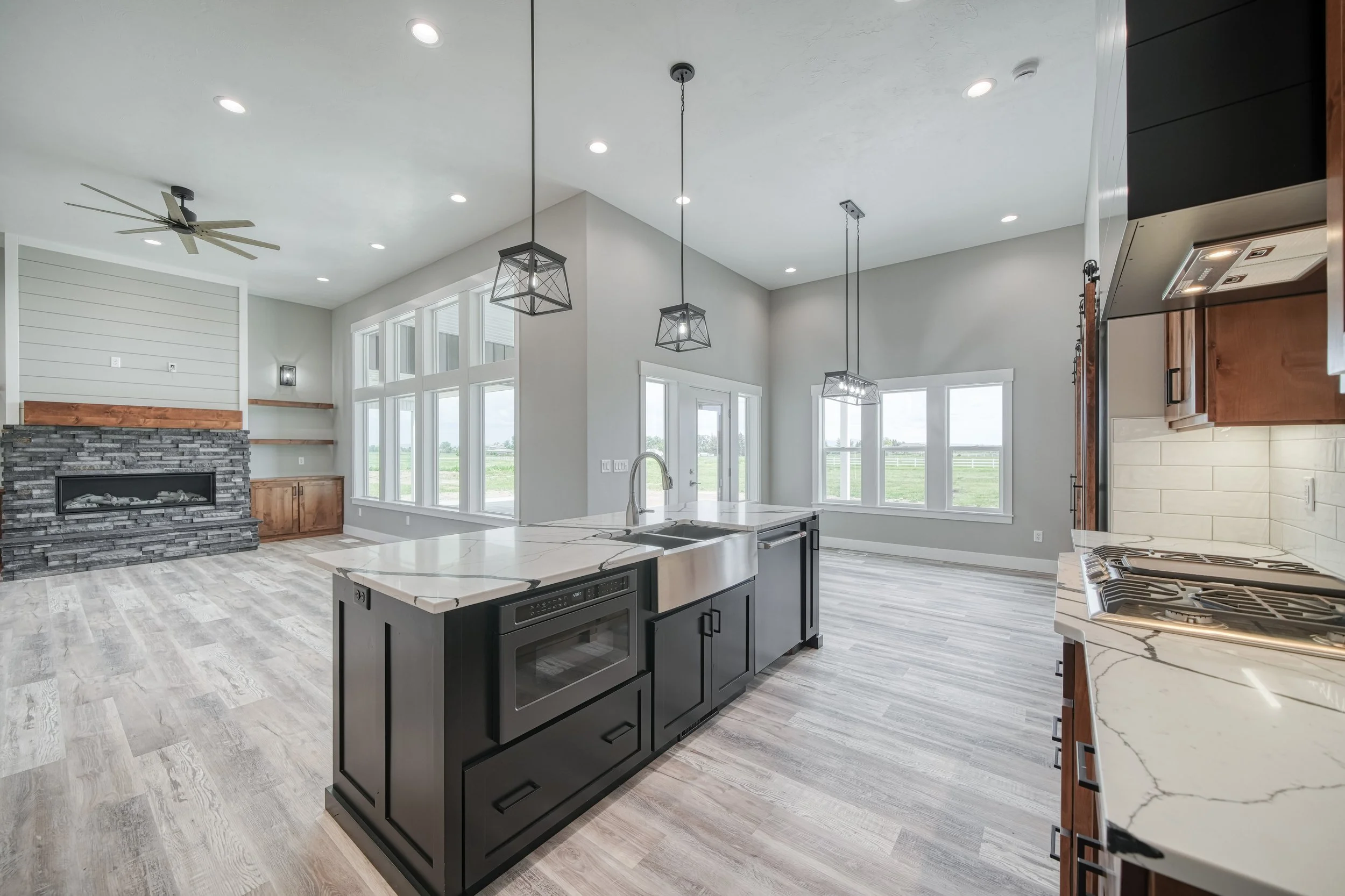 Open kitchen and dining area with large windows — JAB Construction’s Modern Craftsman custom home in Idaho Falls, Idaho.